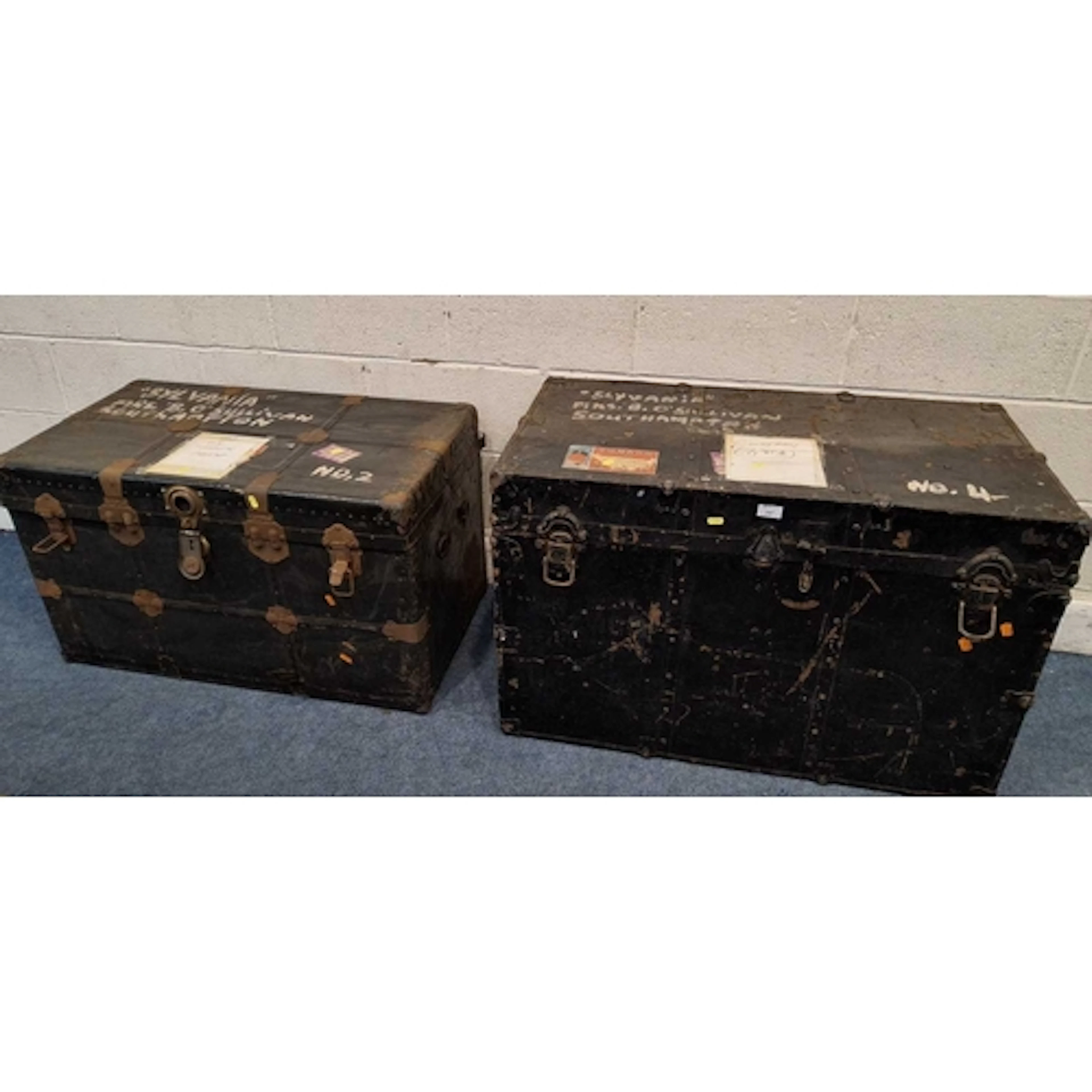 TWO EBONISED TRAVELLING TRUNKS, varying in size, material, e...