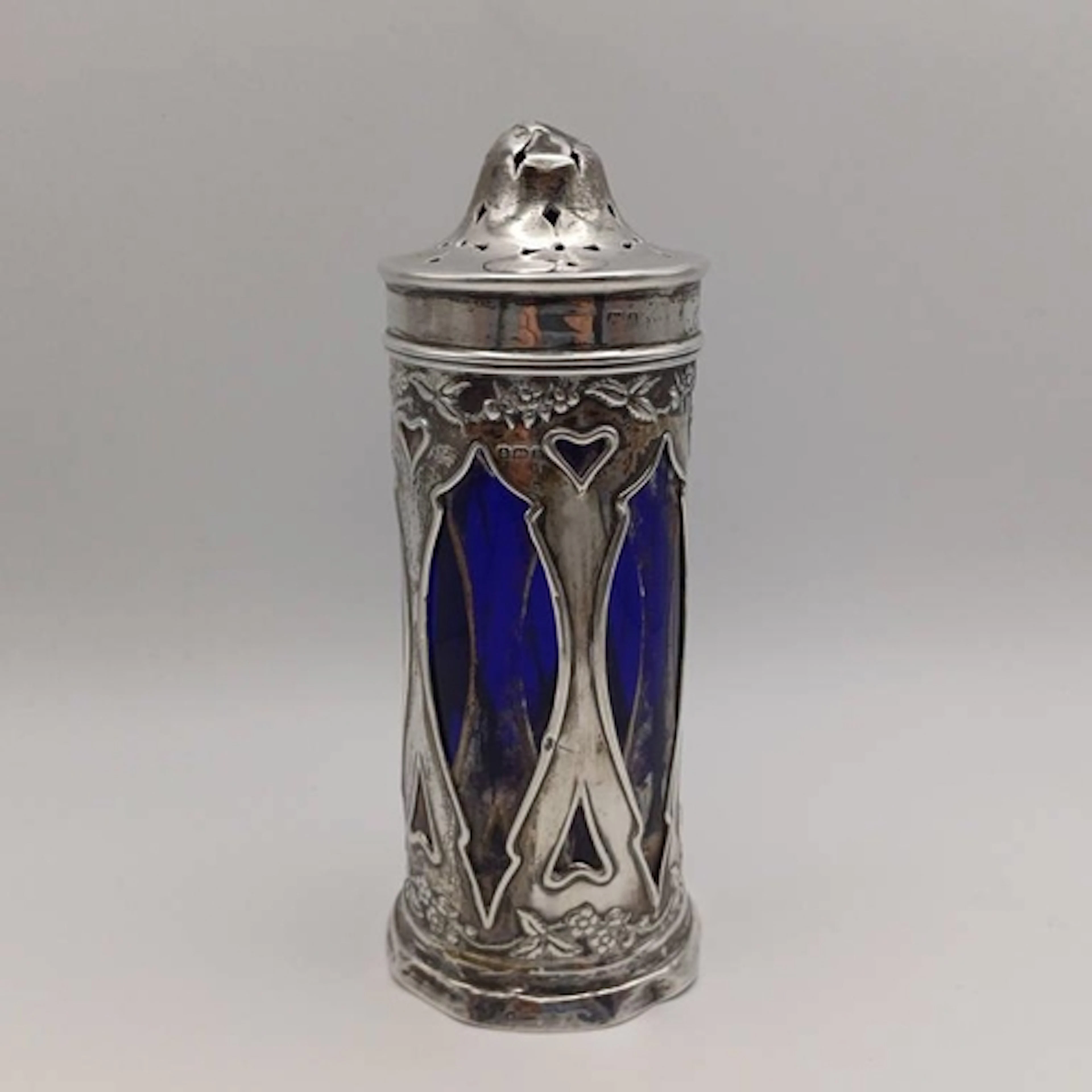 AN ART NOUVEAU SILVER CASTER WITH EMBOSSED BERRY & LEAF DECO...