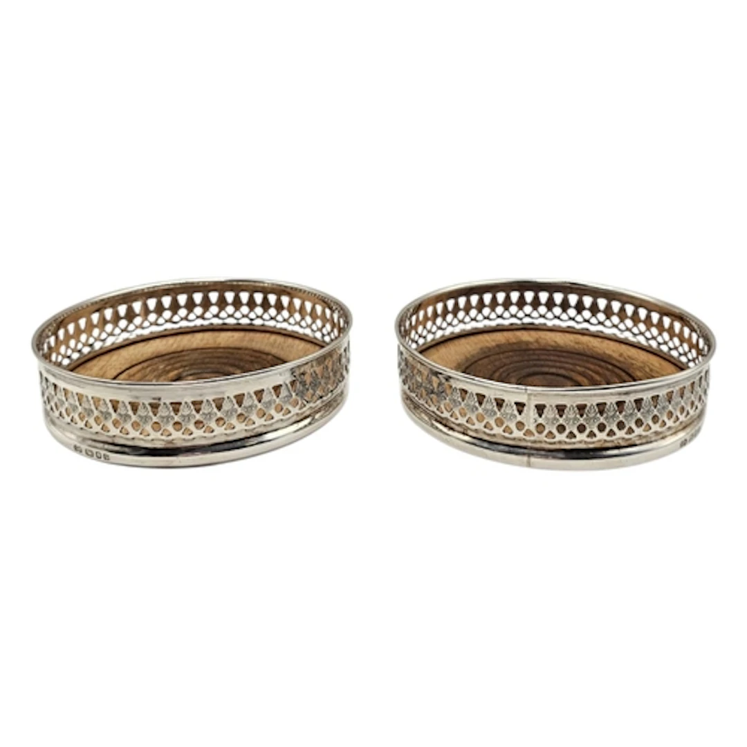 A PAIR OF VINTAGE SILVER WINE COASTERS Having a pierced gall...