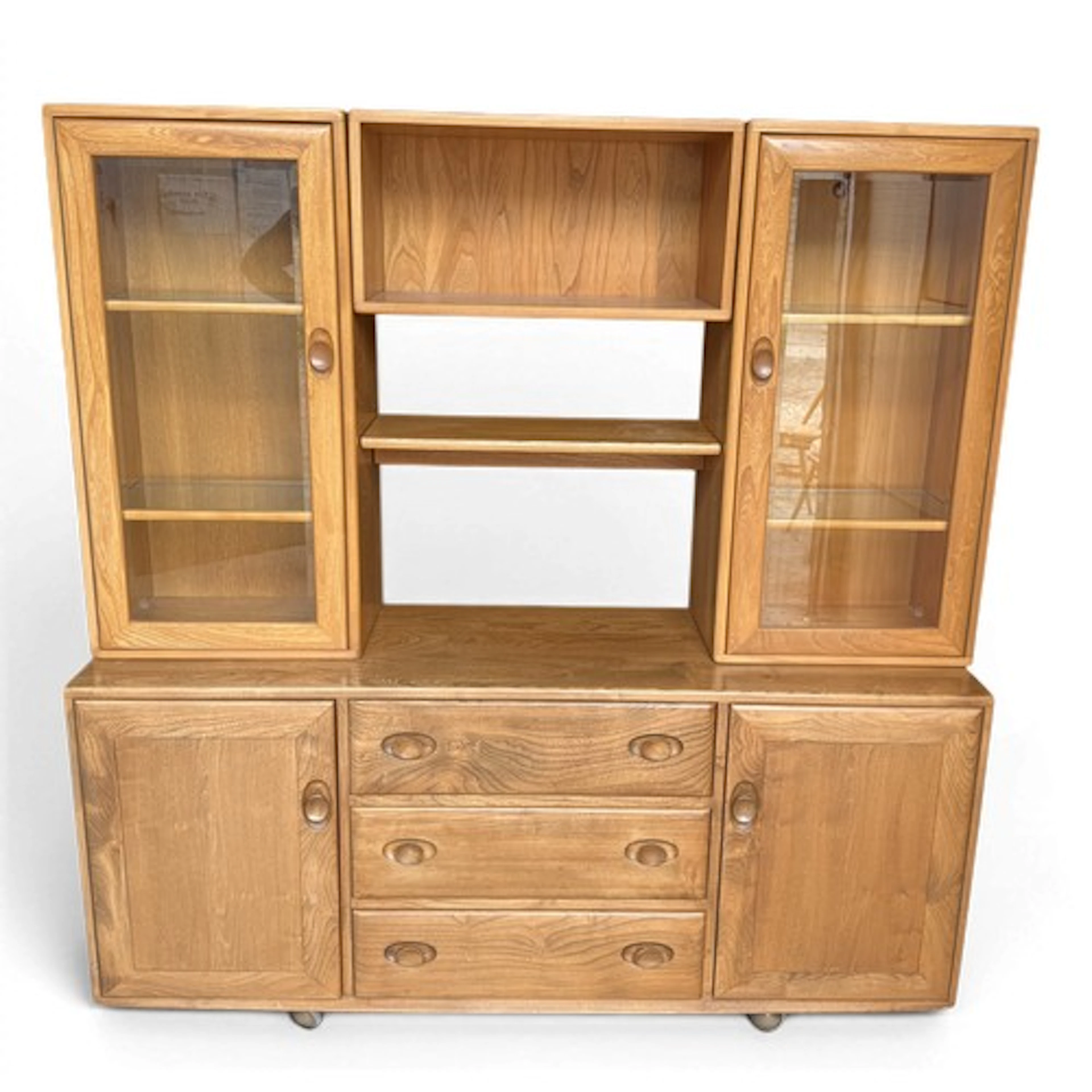 An Ercol sideboard, with bookshelf and glazed cabinets above...