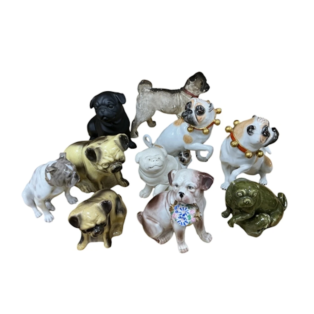 A pair of Meissen style porcelain pugs, one with suckling pu...