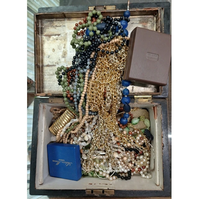 A wooden box containing costume jewellery.