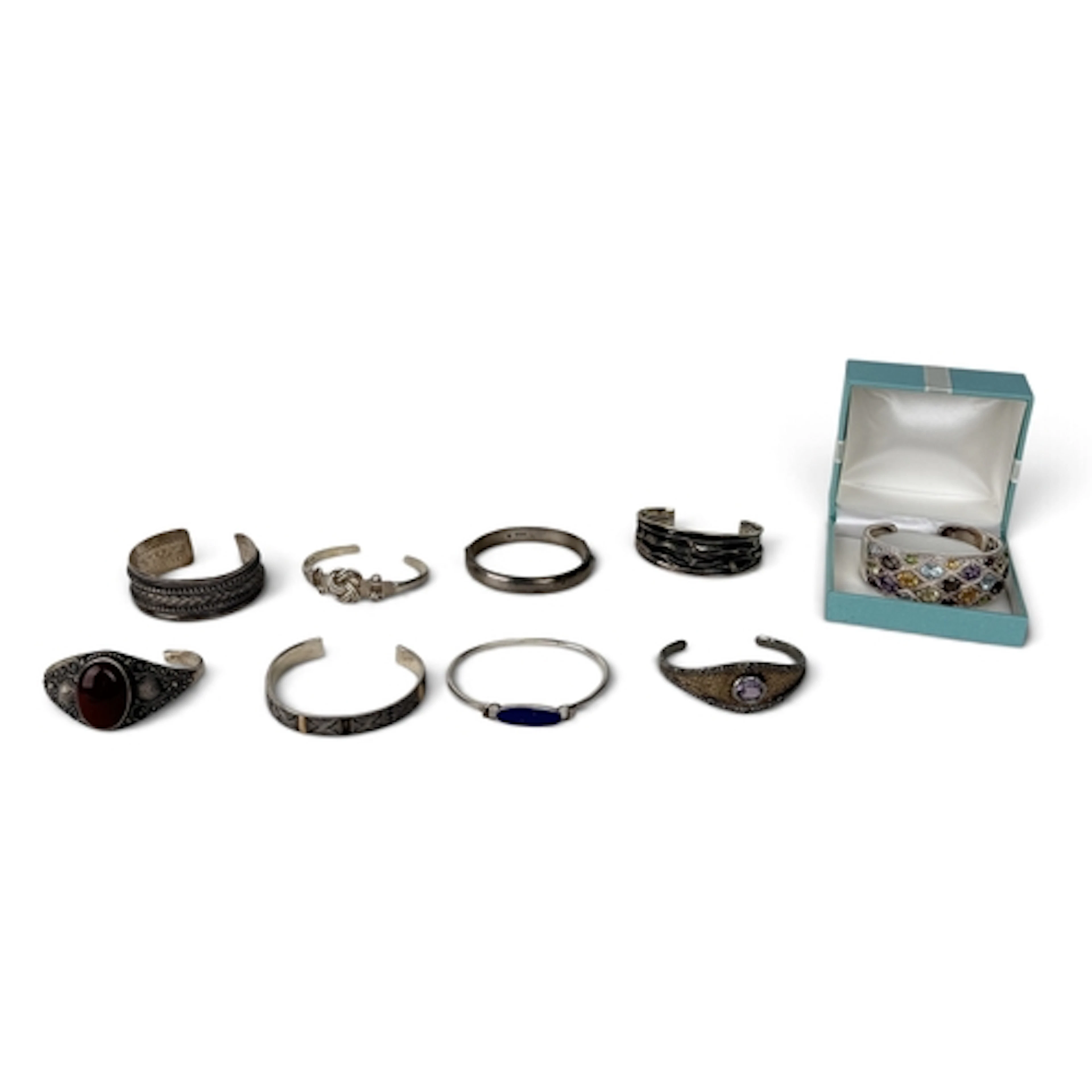 A COLLECTION OF SILVER CUFF BANGLES TO INCLUDE GEM SET, ANTI...
