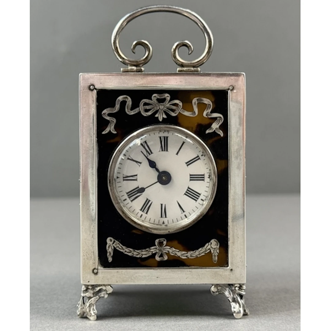 Decorative Arts: a silver and tortoiseshell boudoir clock, L...