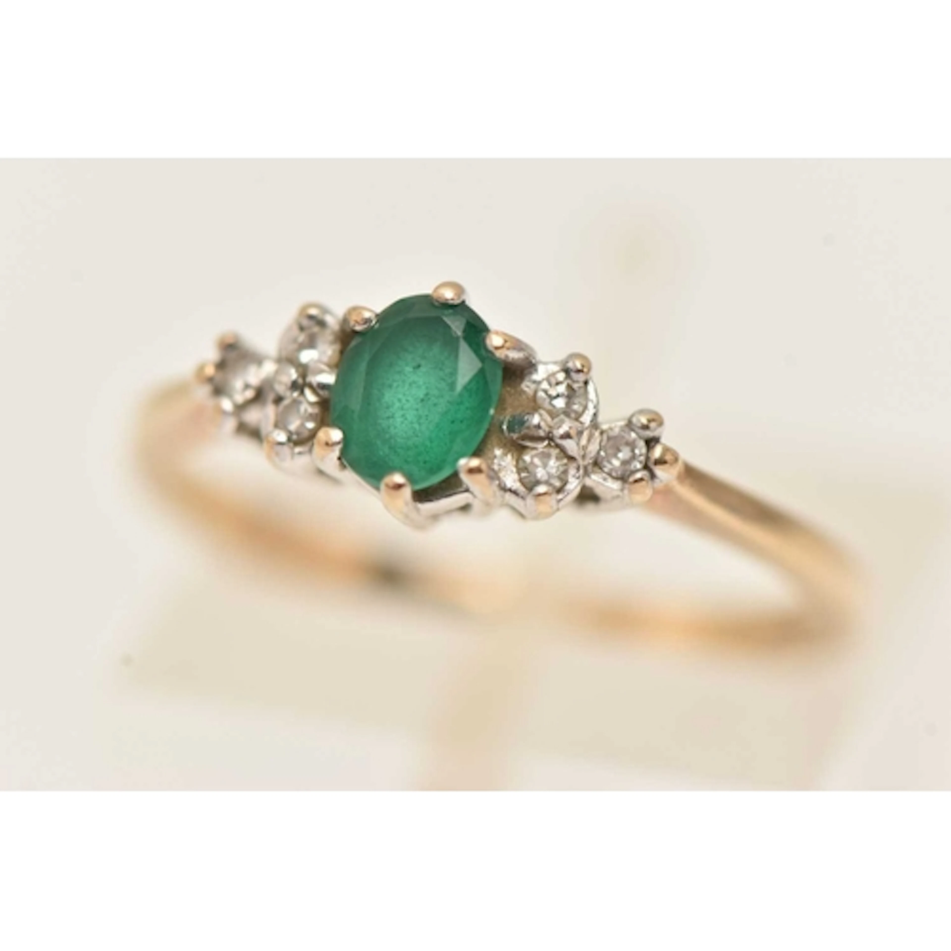A 9CT GOLD EMERALD AND DIAMOND RING, set with a central oval...