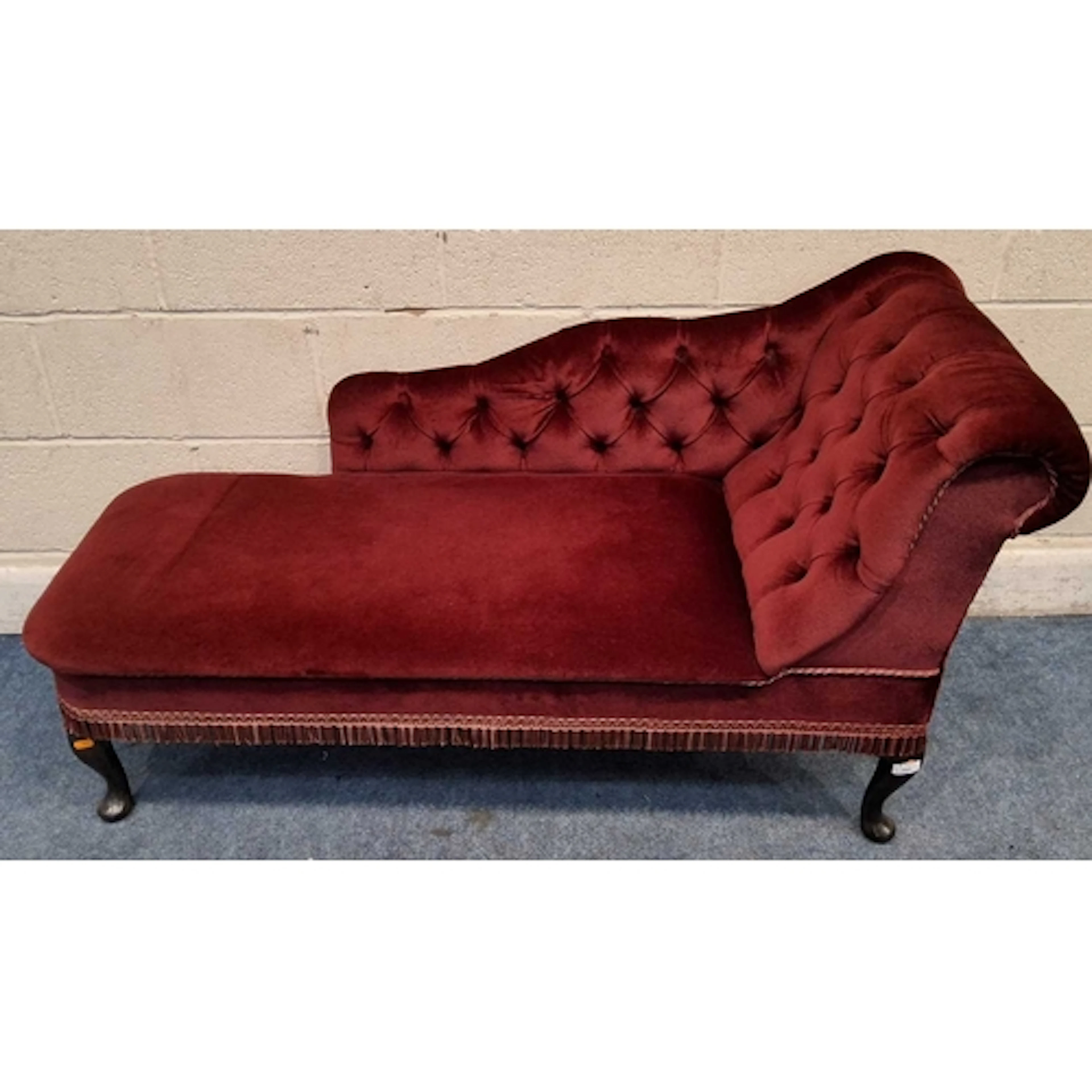 A 20TH CENTURY CHAISE LONGUE, with buttoned upholstery, rais...