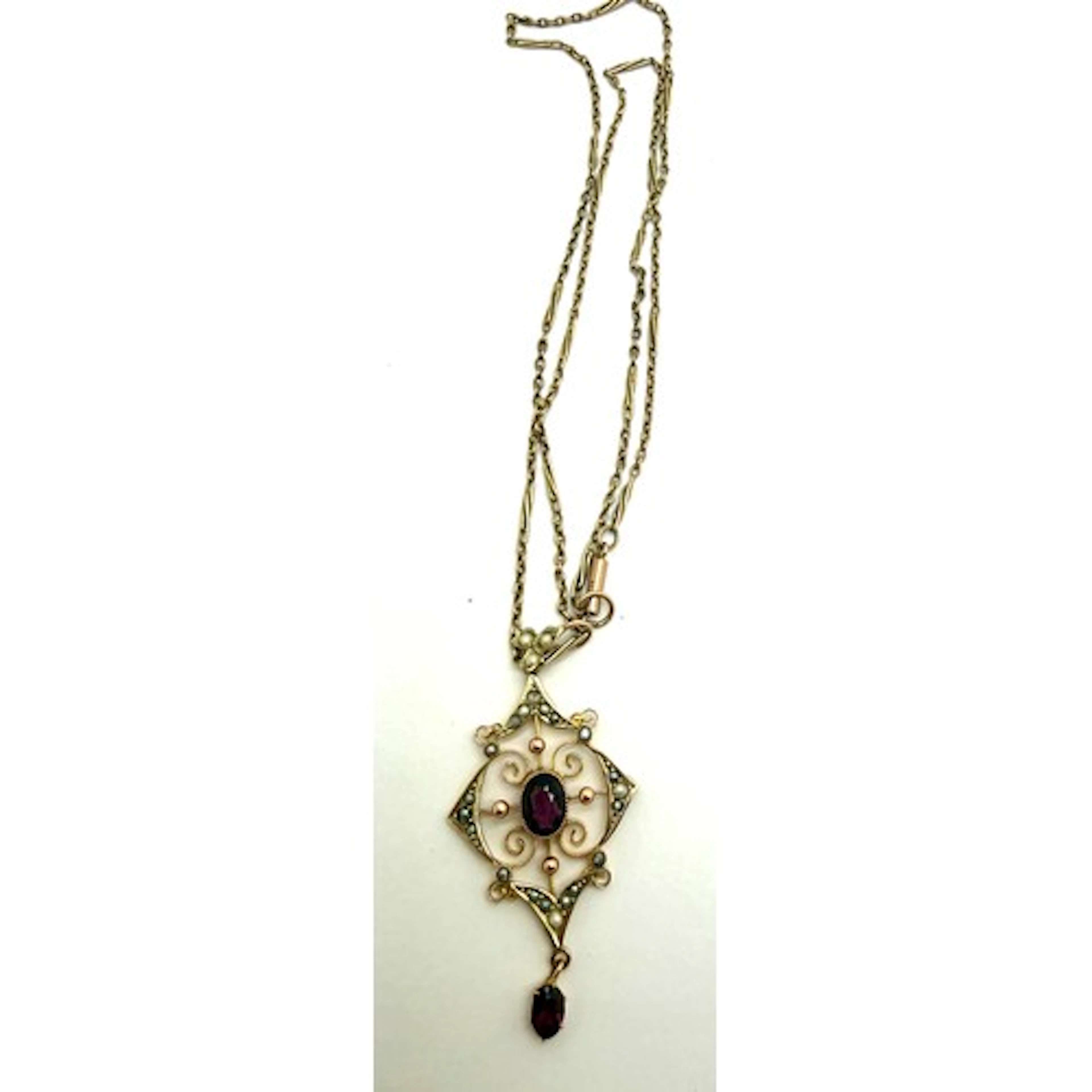 A 9 carat gold pendant set with seed pearls and garnets susp...