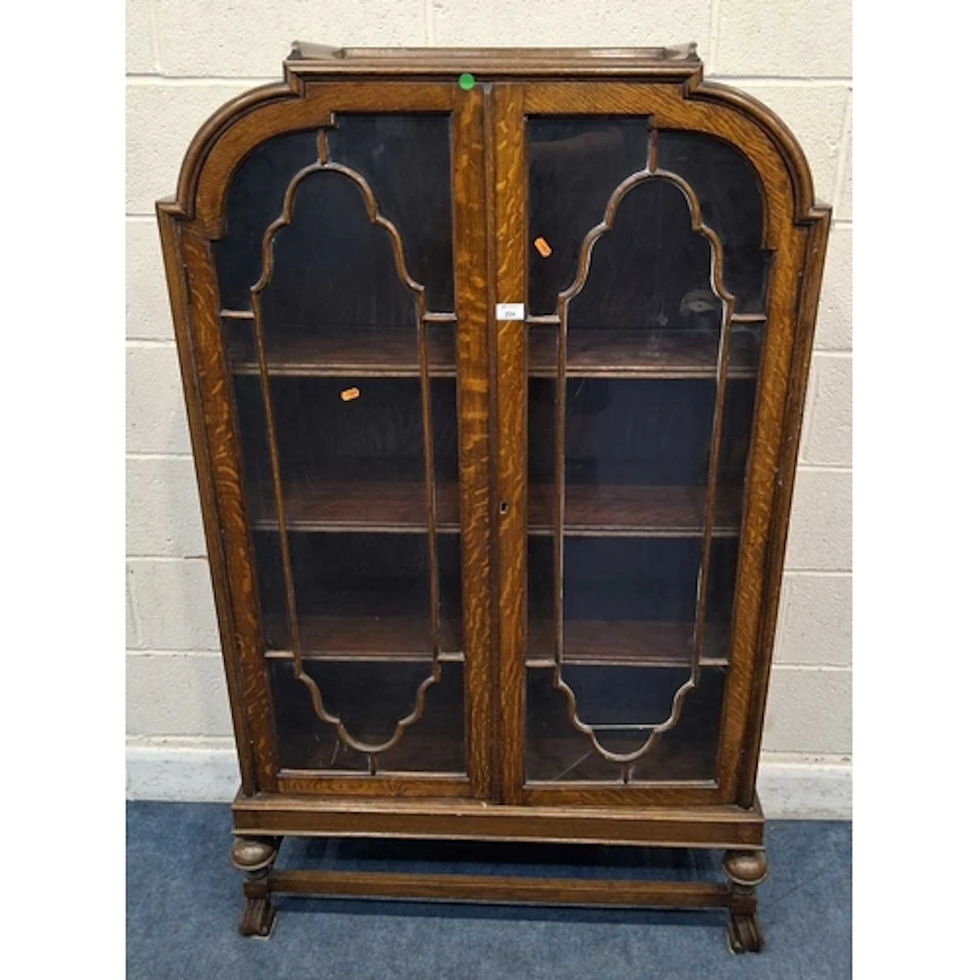AN EARLY 20TH CENTURY OAK BOOKCASE, the double glass doors e...