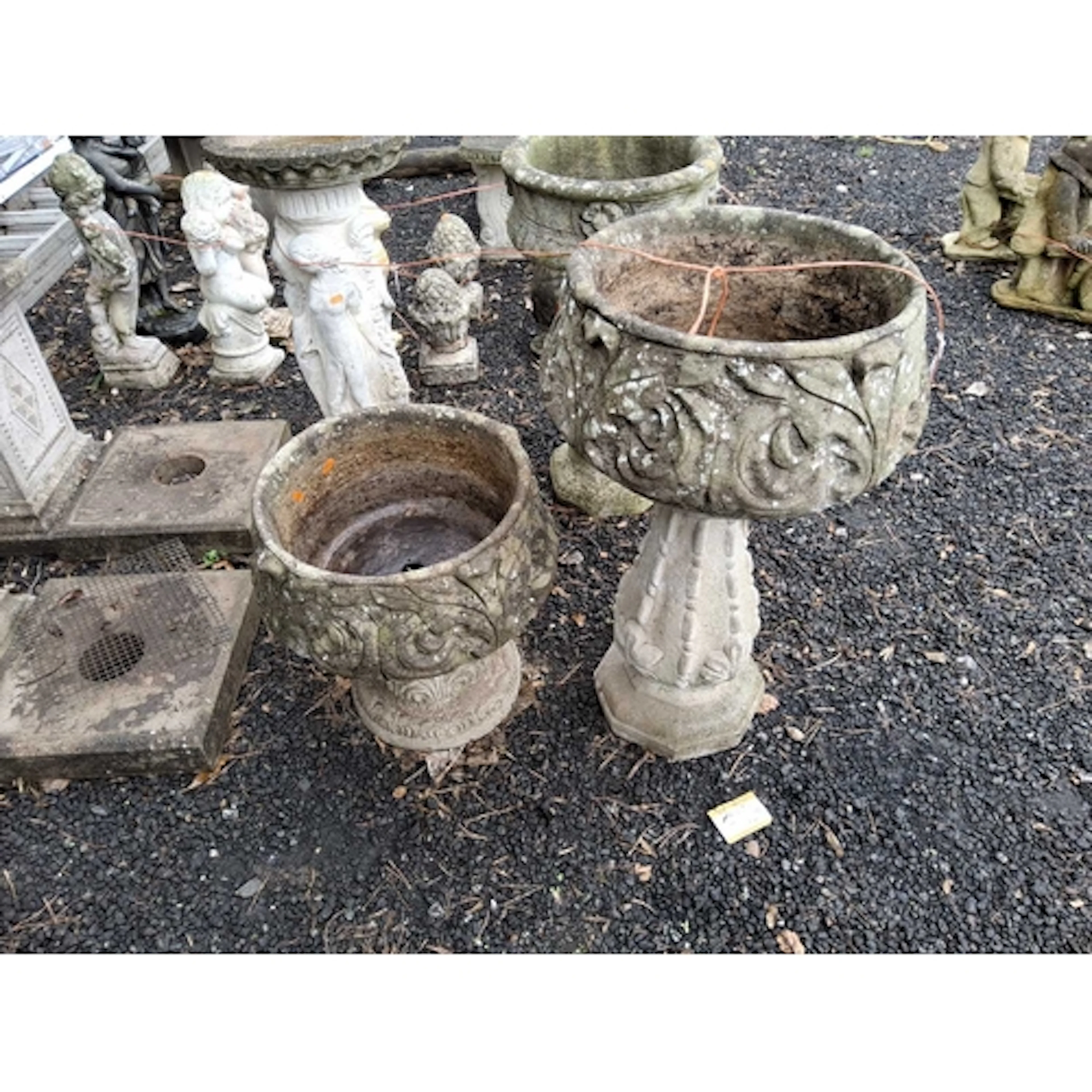 A PAIR OF ACANTHUS LEAF EFFECT CONCRETE PLANTERS, one on a t...