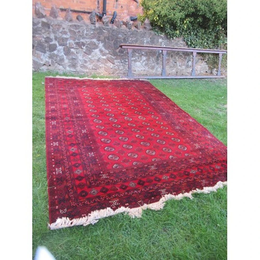 A large red ground Bokhara rug 138ins x 97ins