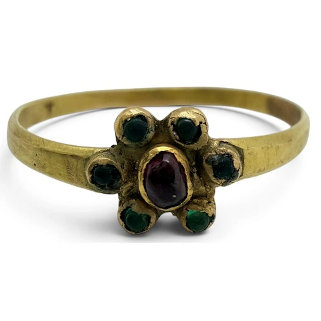 A slender medieval gold ring with a flowerhead bezel, centre...