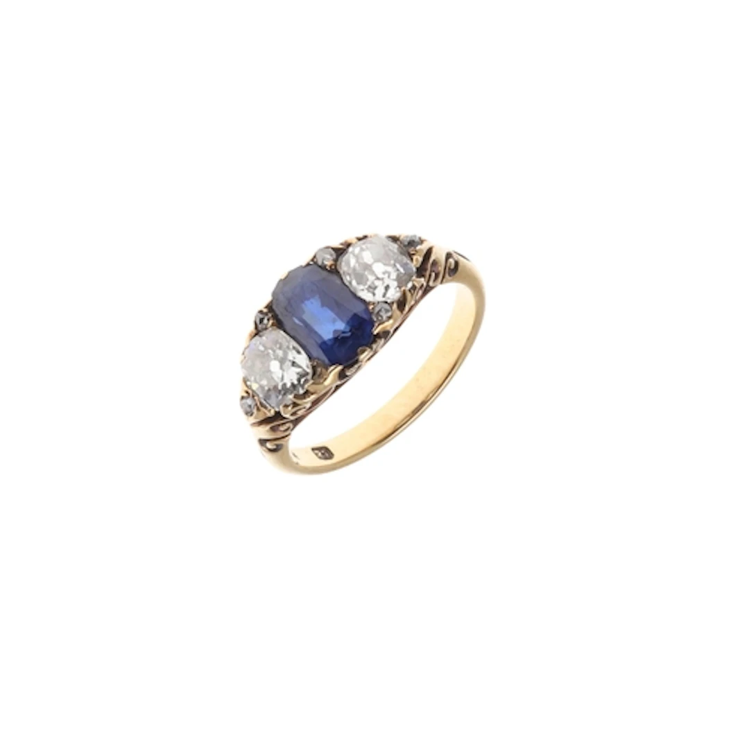 A SAPPHIRE AND DIAMOND THREE STONE RING. the oval-shaped sap...