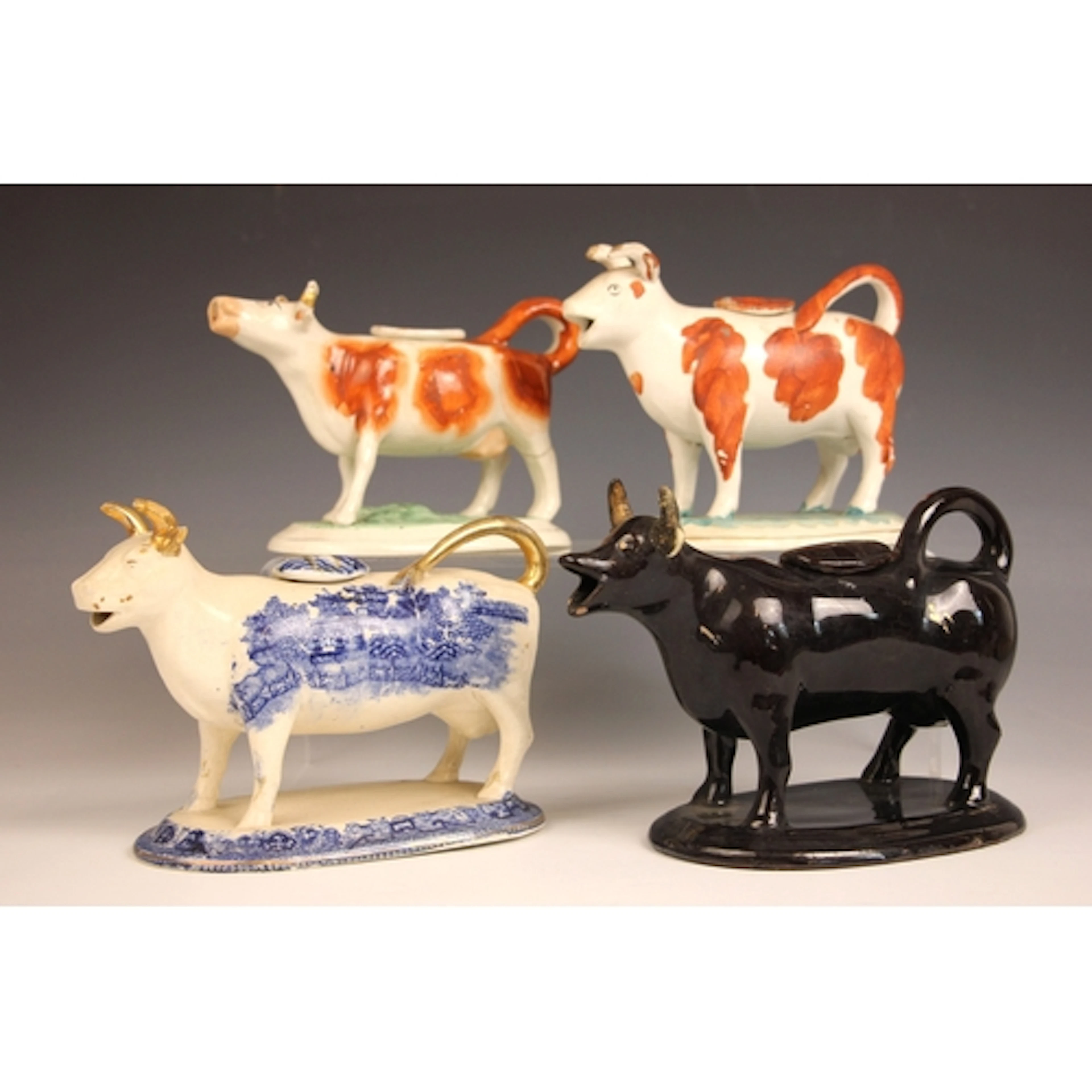 Four Staffordshire cow creamers and covers, 19th century, co...