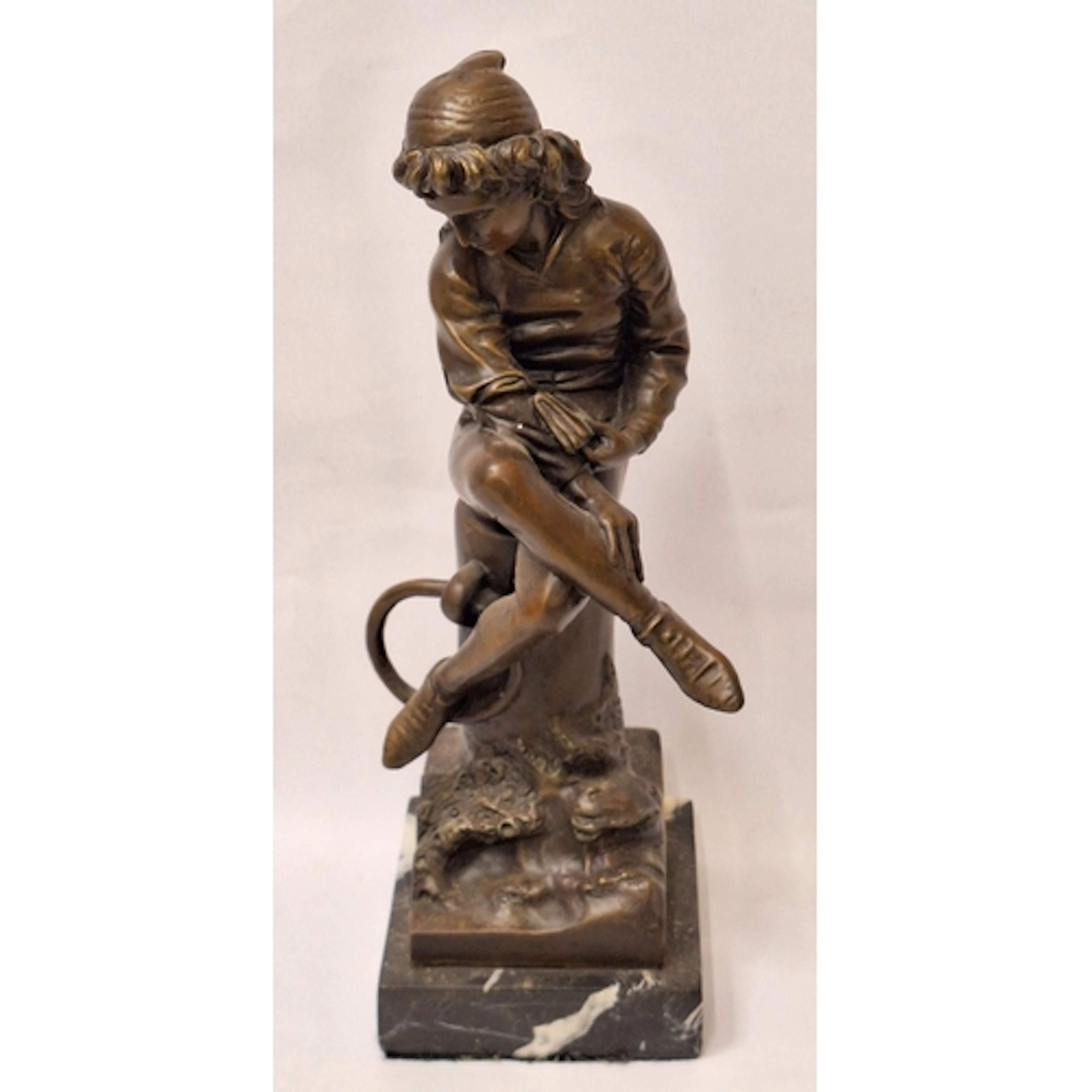 Bronze Sculpture Young Man sitting on a tree trunk in the st...