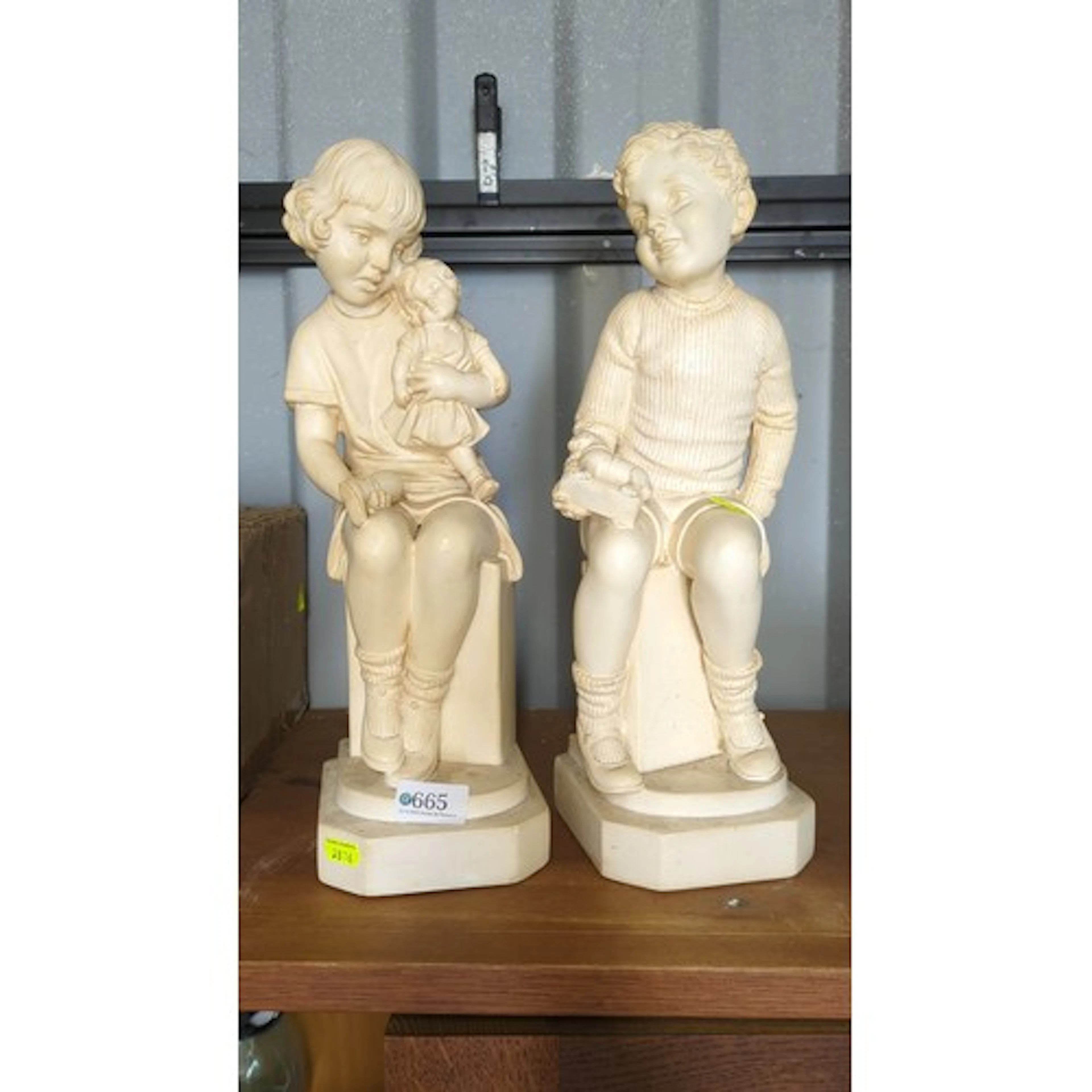 A pair of moulded figural garden ornaments in cream-painted ...