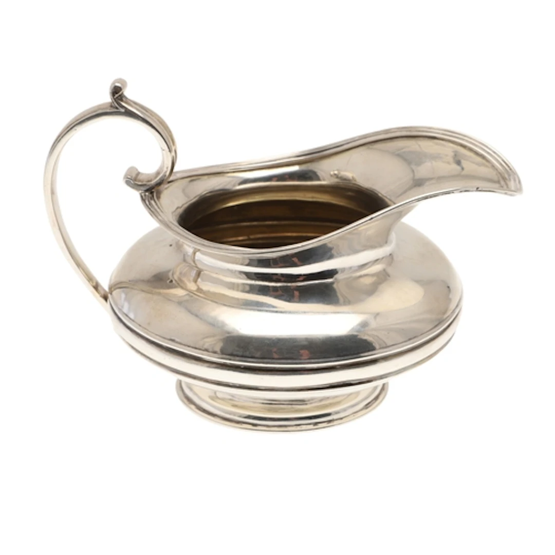 A WILLIAM IV SILVER MILK JUG. The bulbous body with a reeded...
