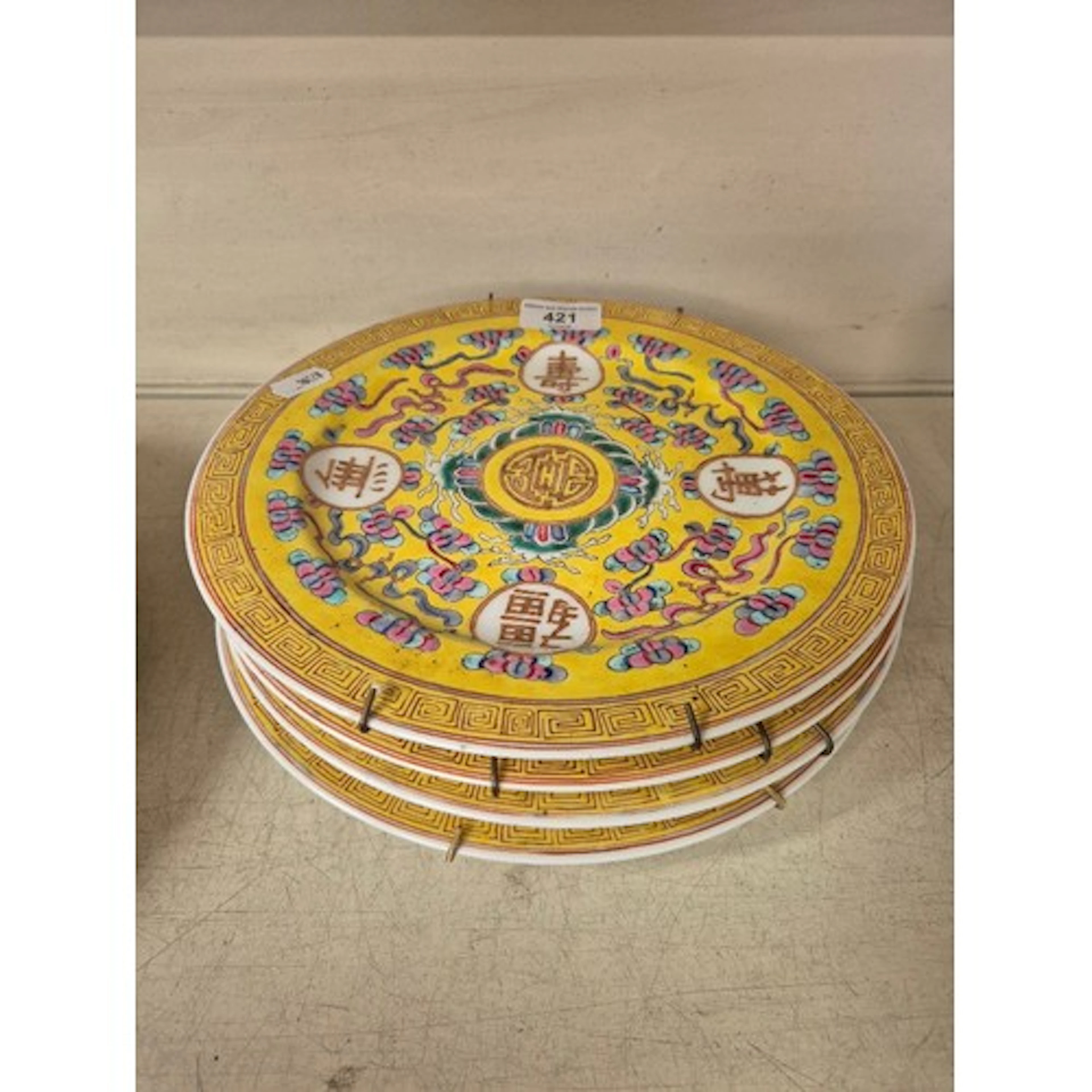 Four vintage Chinese famille rose plates on yellow ground, e...