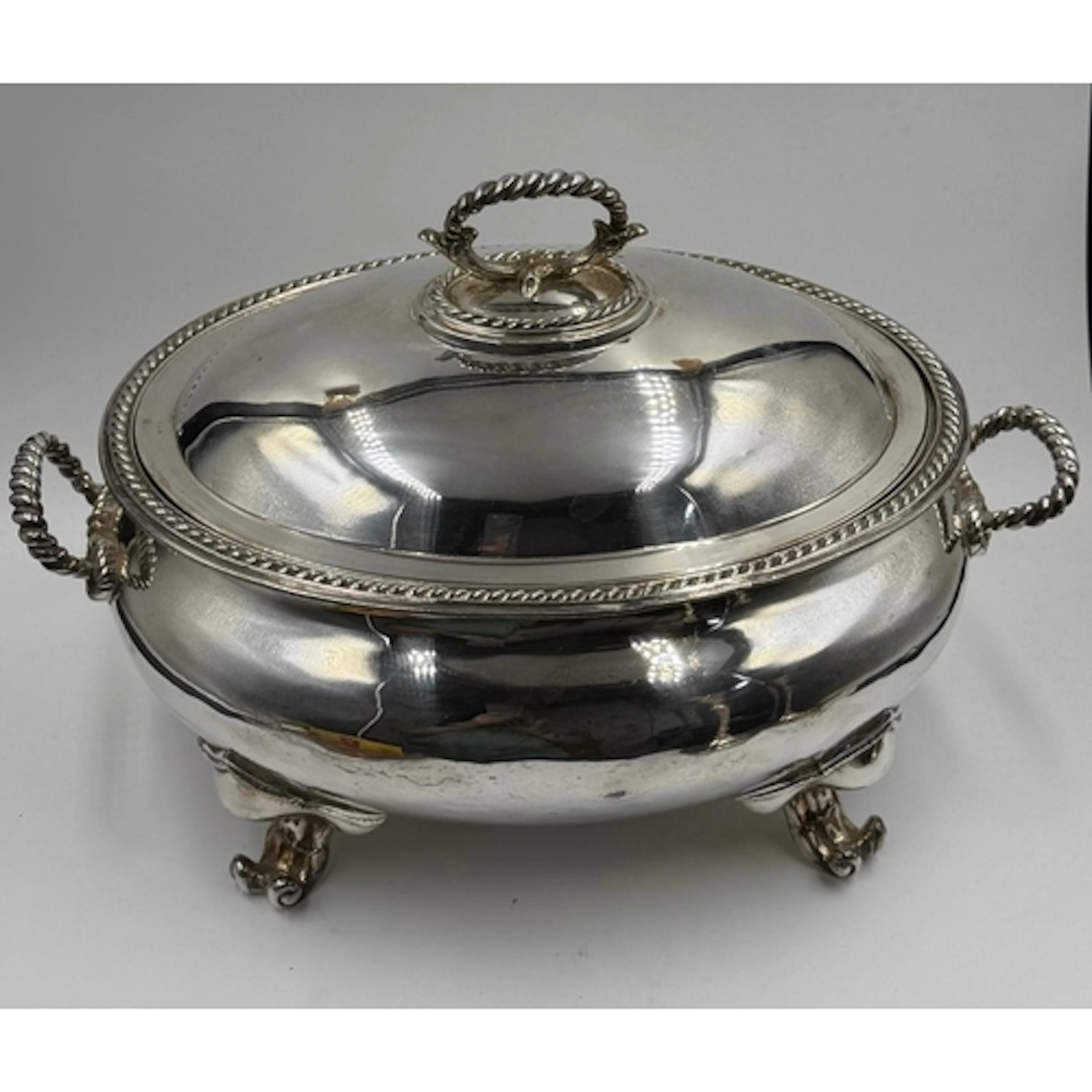 A silverplate lidded tureen on scroll feet with twisted hand...