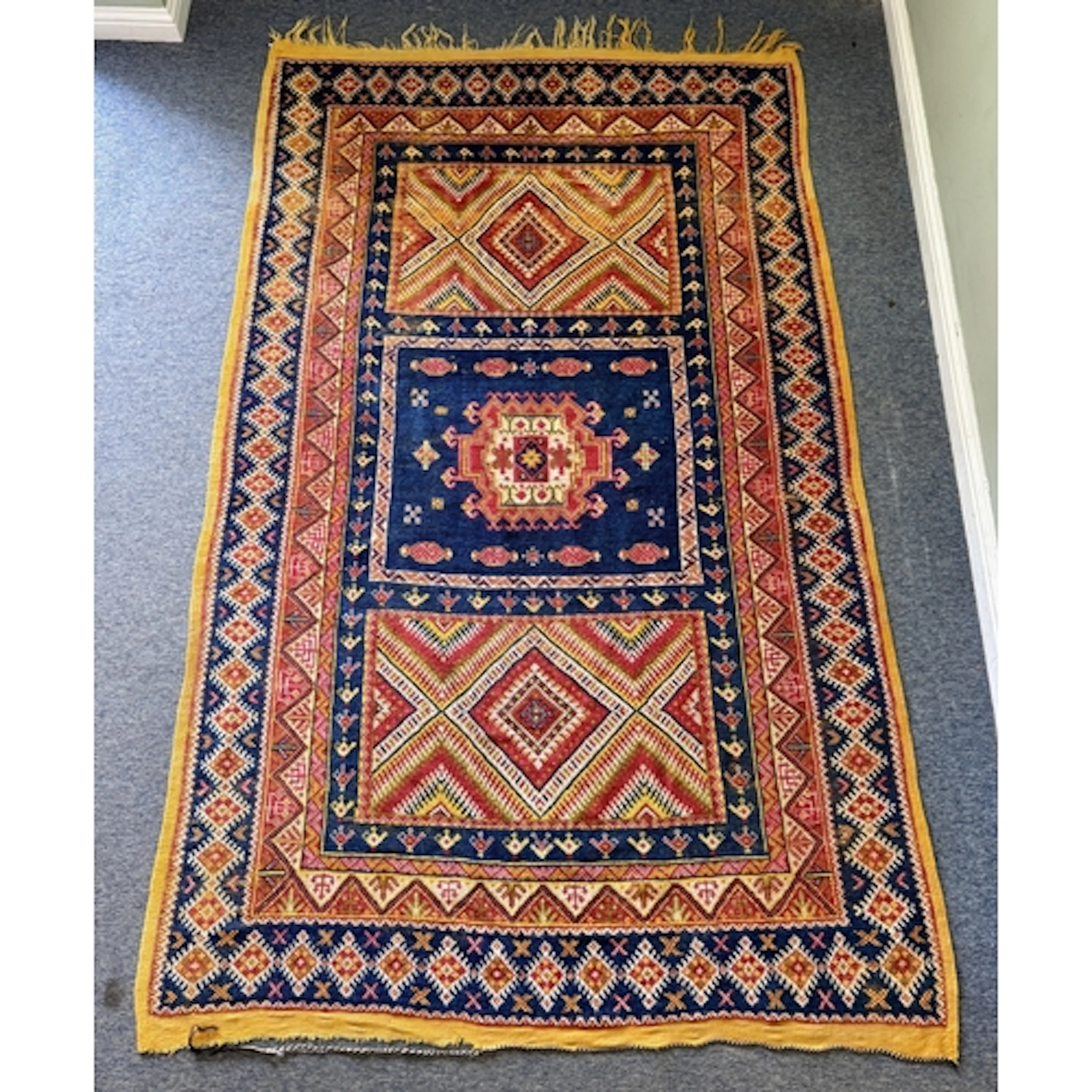 A Moroccan hand knotted wool rug - the three panel field wit...