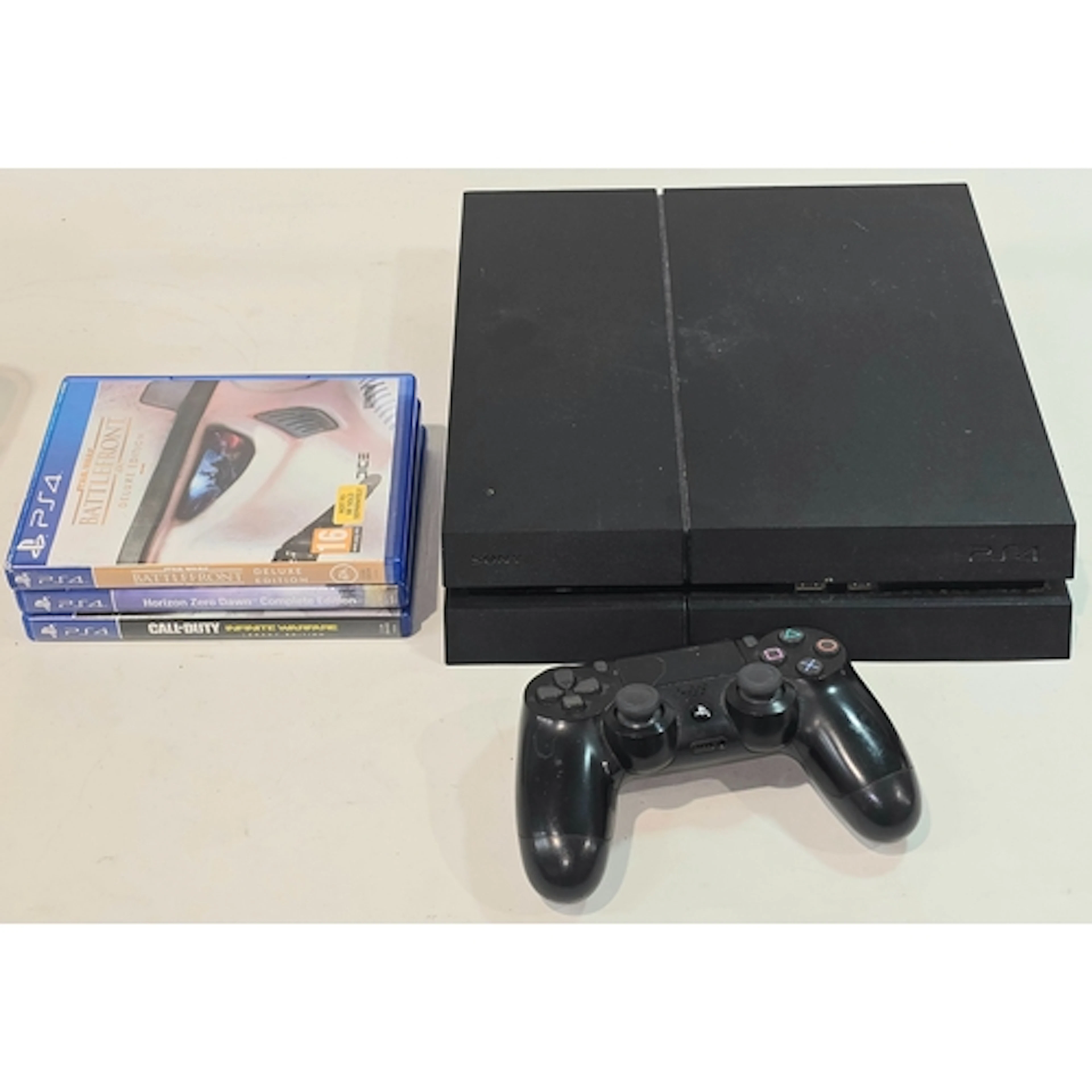 A Sony PS4 console together with one controller and three ga...