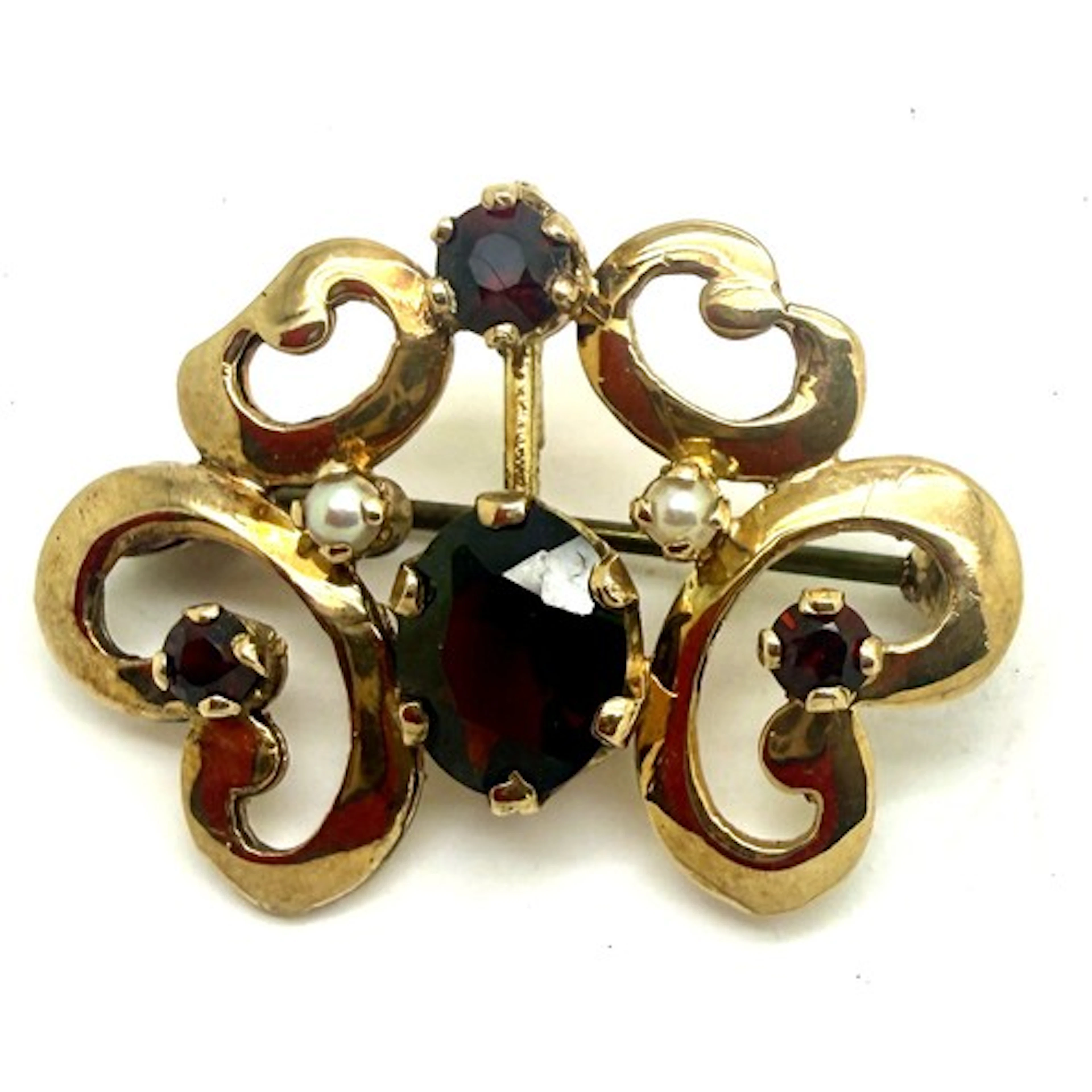 A 9 carat gold brooch/pendant set with red stones and seed ...
