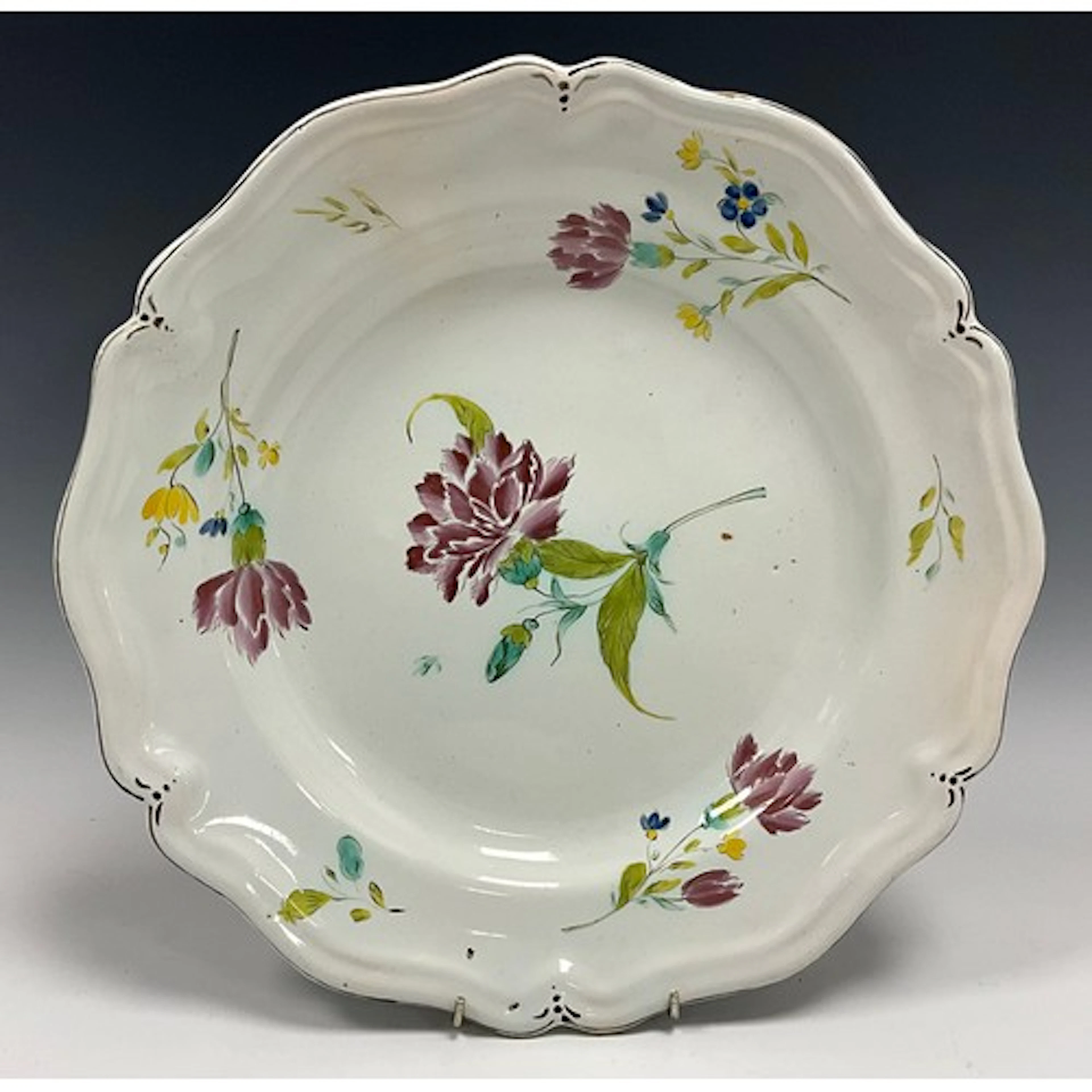 A Rouen faience charger, the tin-glazed dish painted with fl...