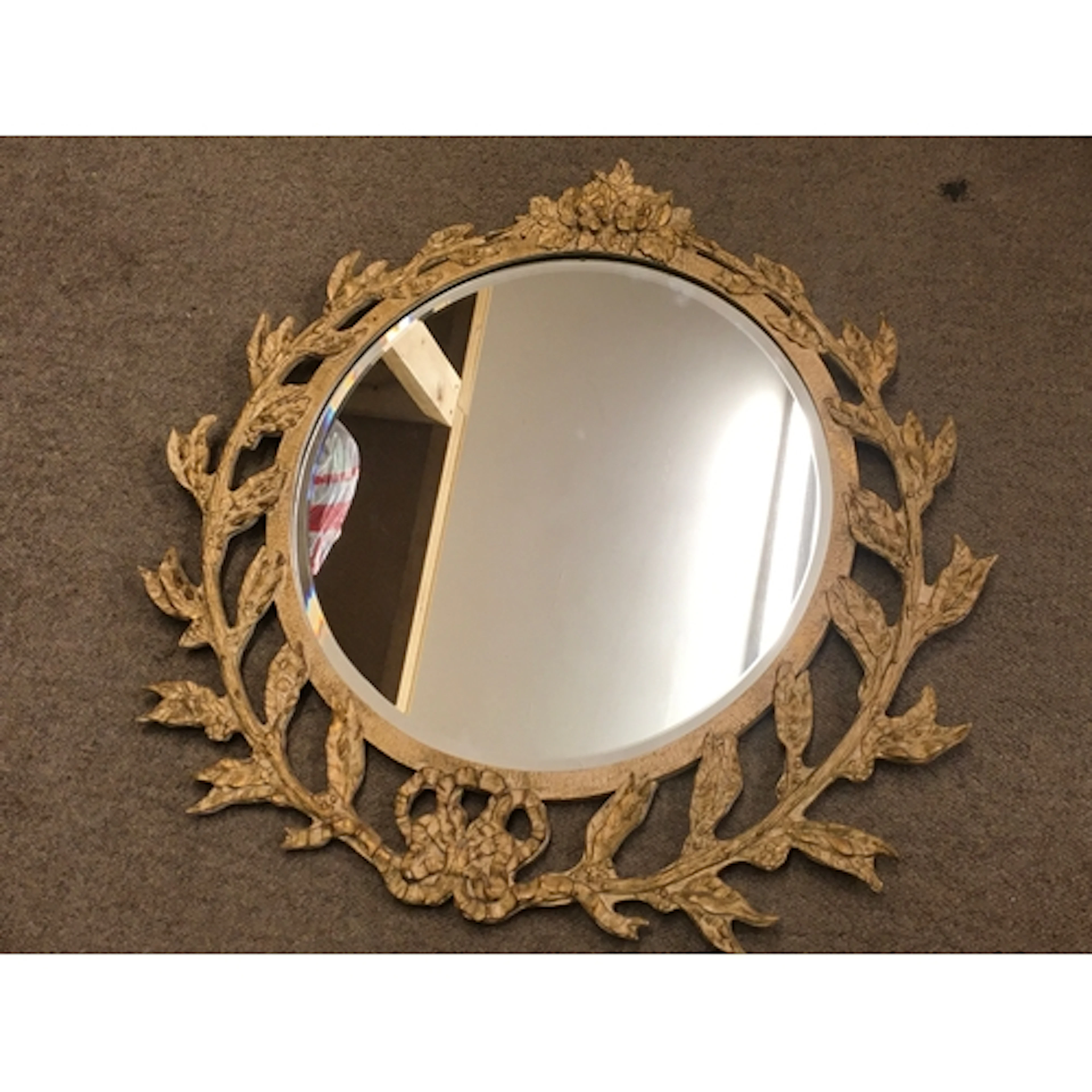 A composite mirror with leaf / foliage design 68cm wide 64cm...