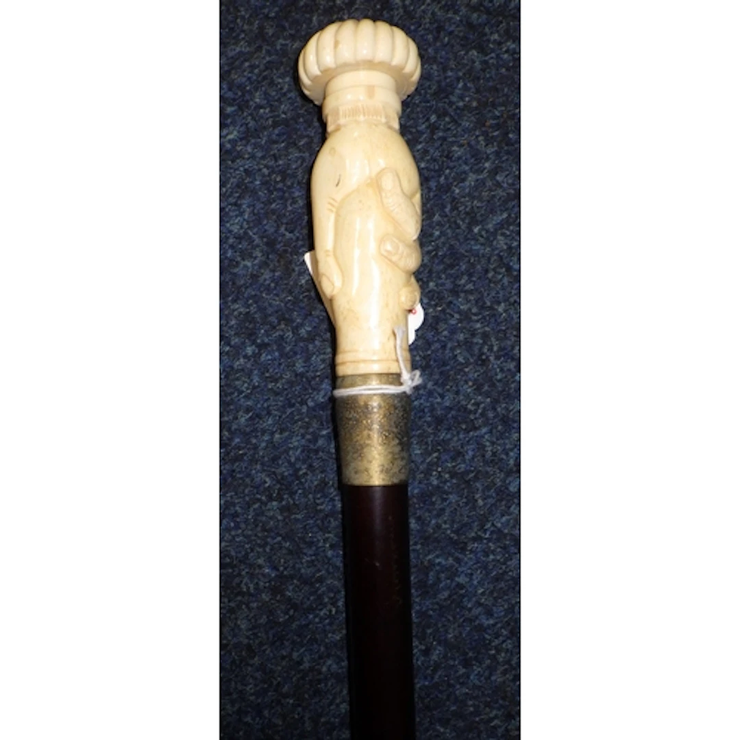 A bone handled walking stick with handle in the form of a ha...