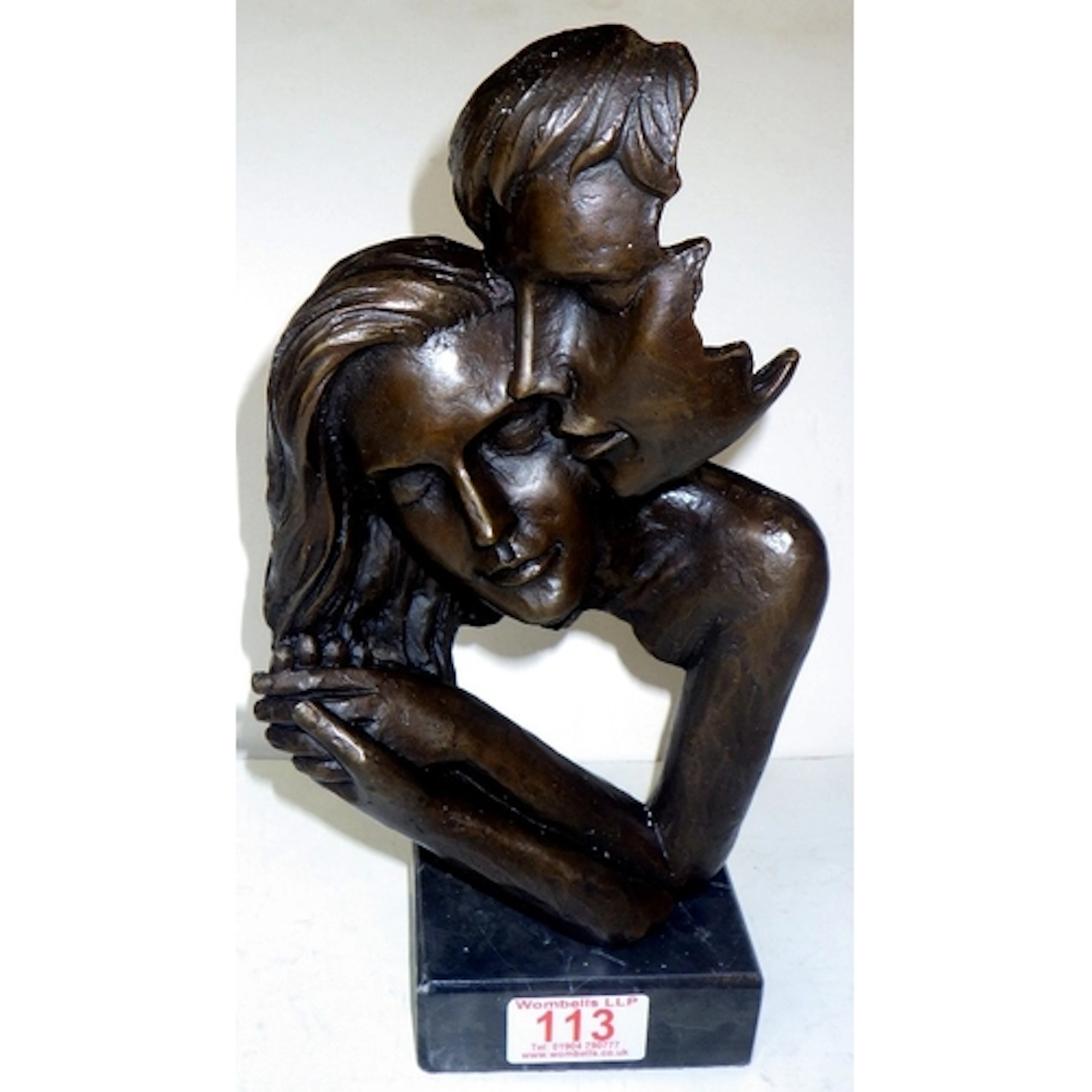 A modern patinated bronze sculpture of Couple Kissing, on a ...