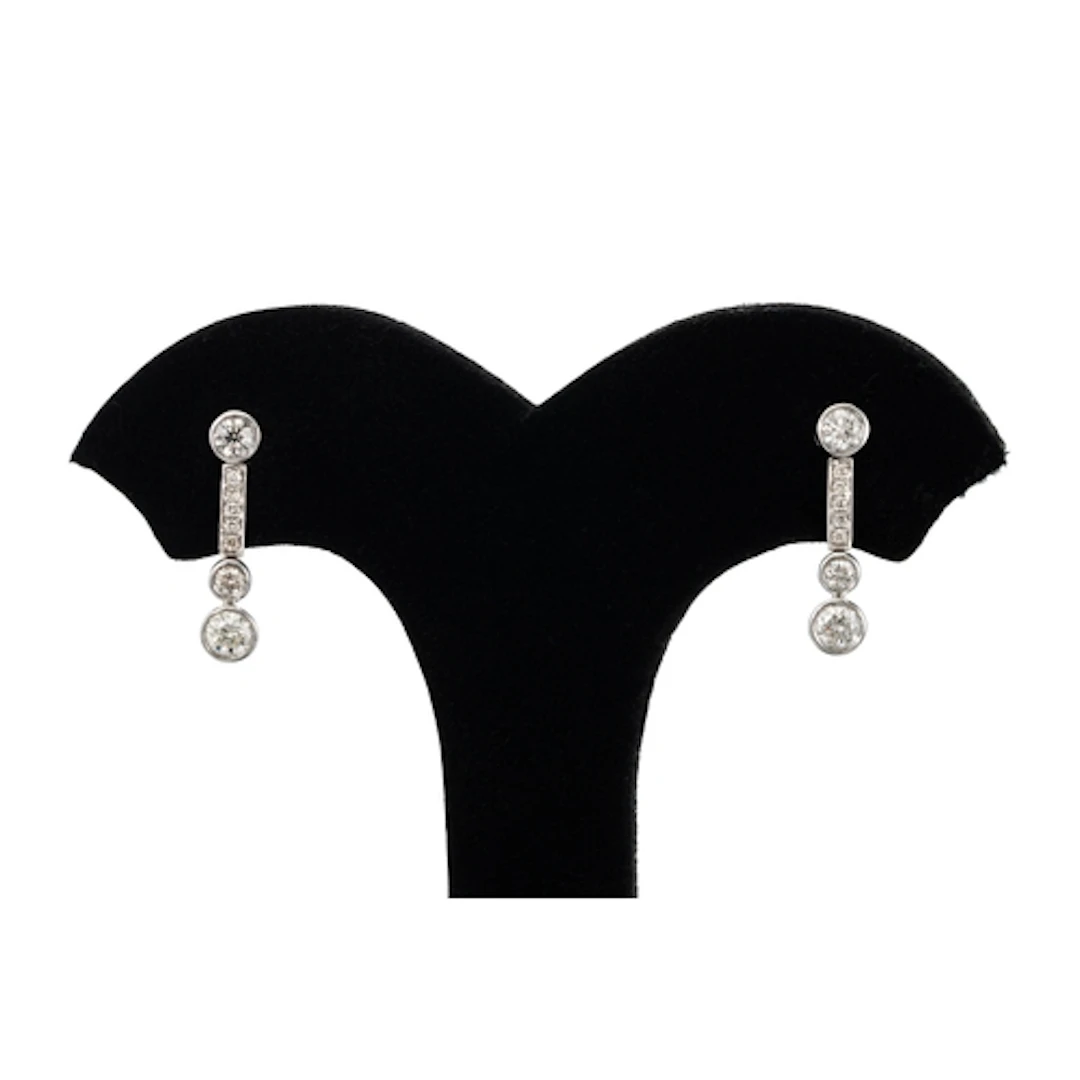A PAIR OF DIAMOND DROP EARRINGS, the bezel set round brillia...