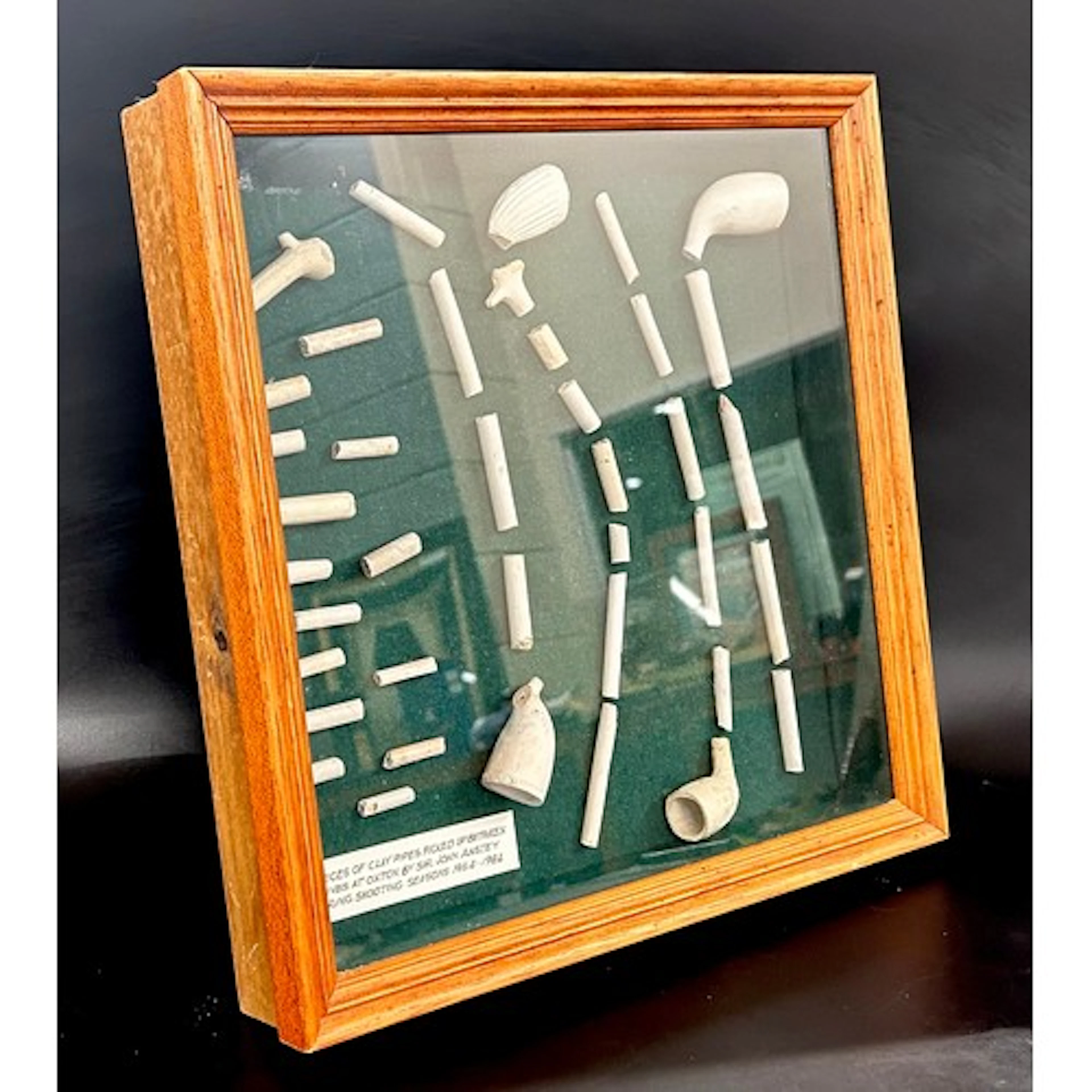 A cased display of clay pipes