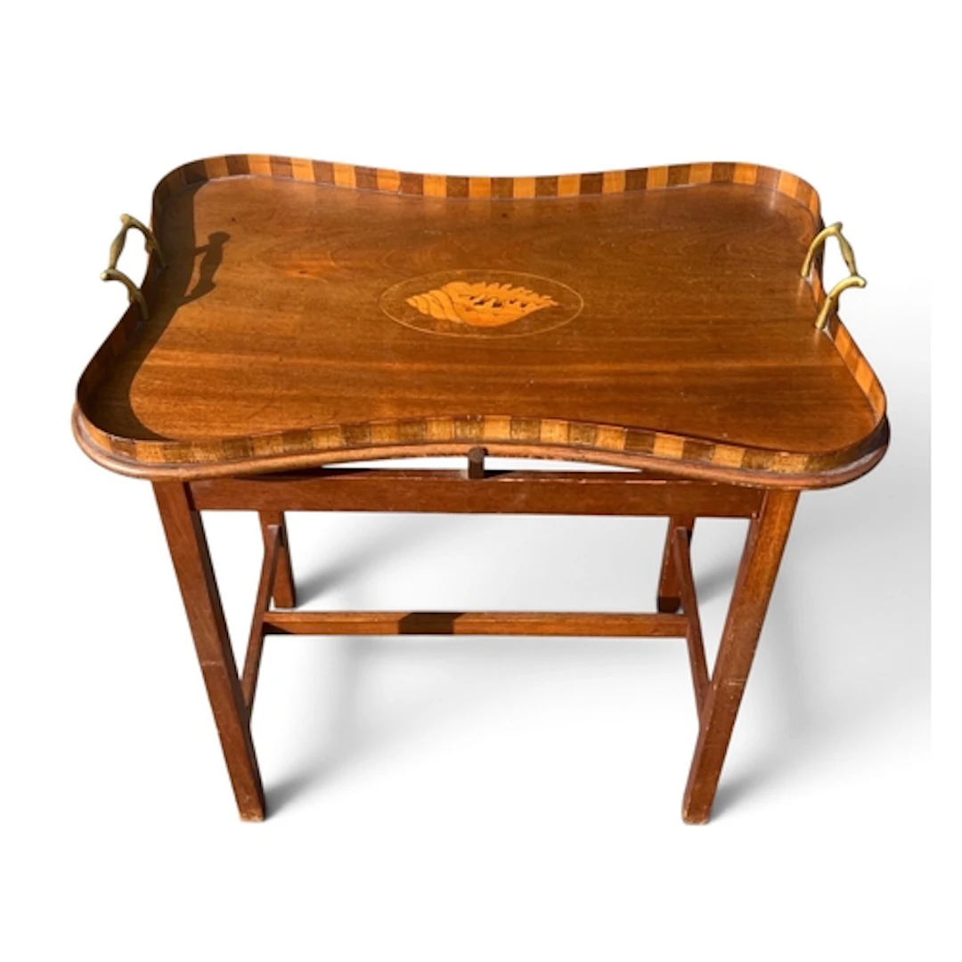AN EDWARDIAN MAHOGANY SHAPED TRAY TABLE The top with marquet...