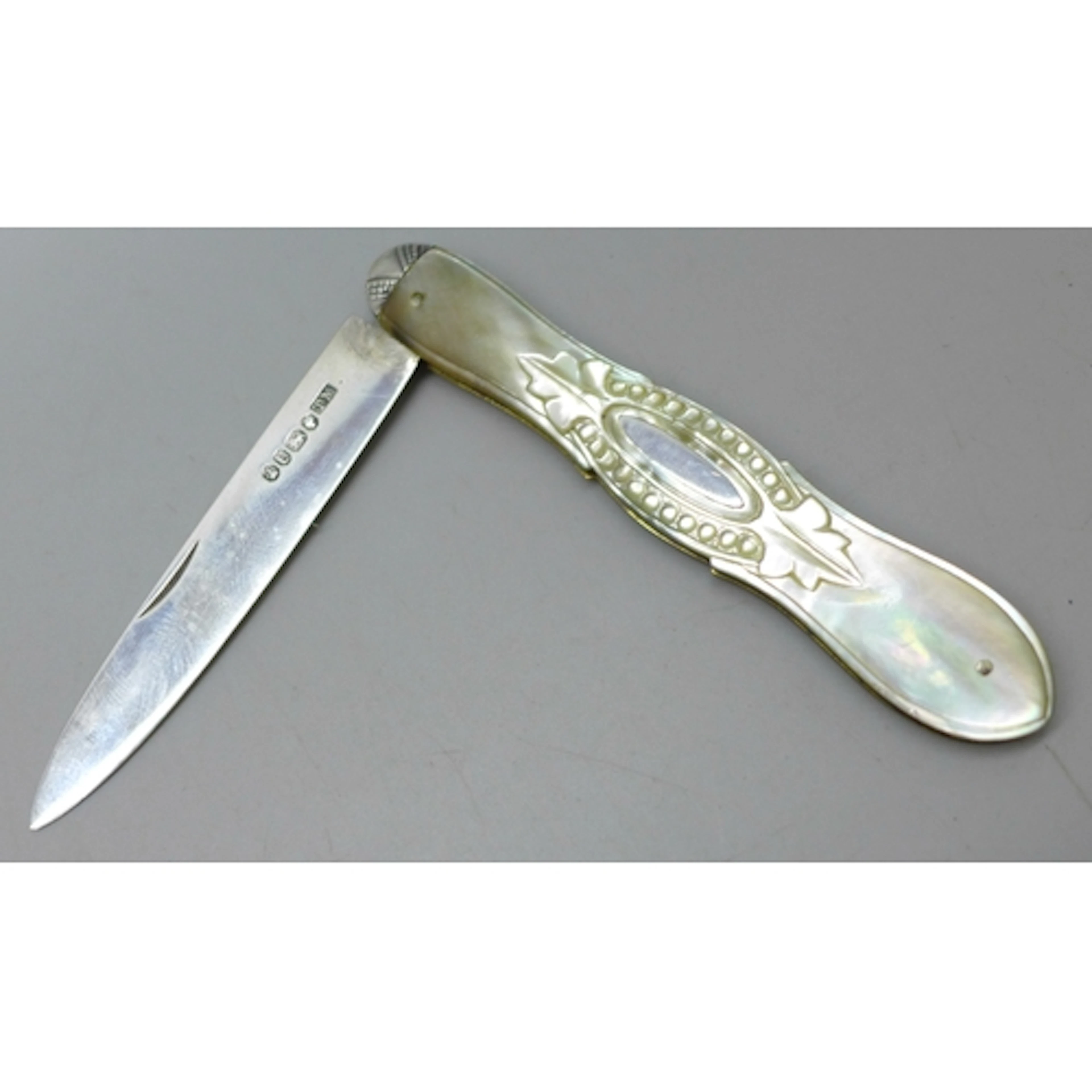 A Victorian carved mother of pearl fruit knife with a silver...