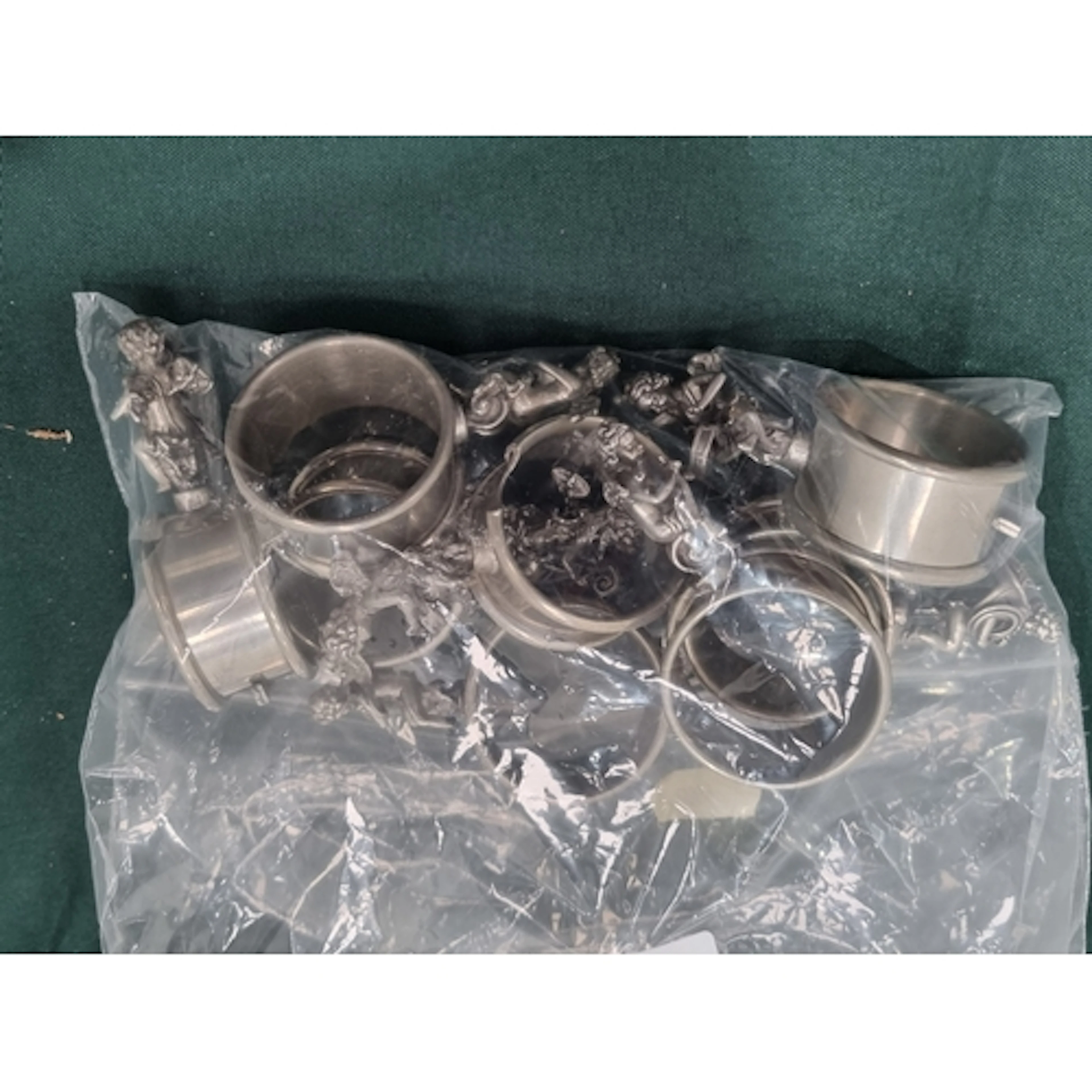 A set of pewter Napkin Rings with winged cherub surmounts pl...