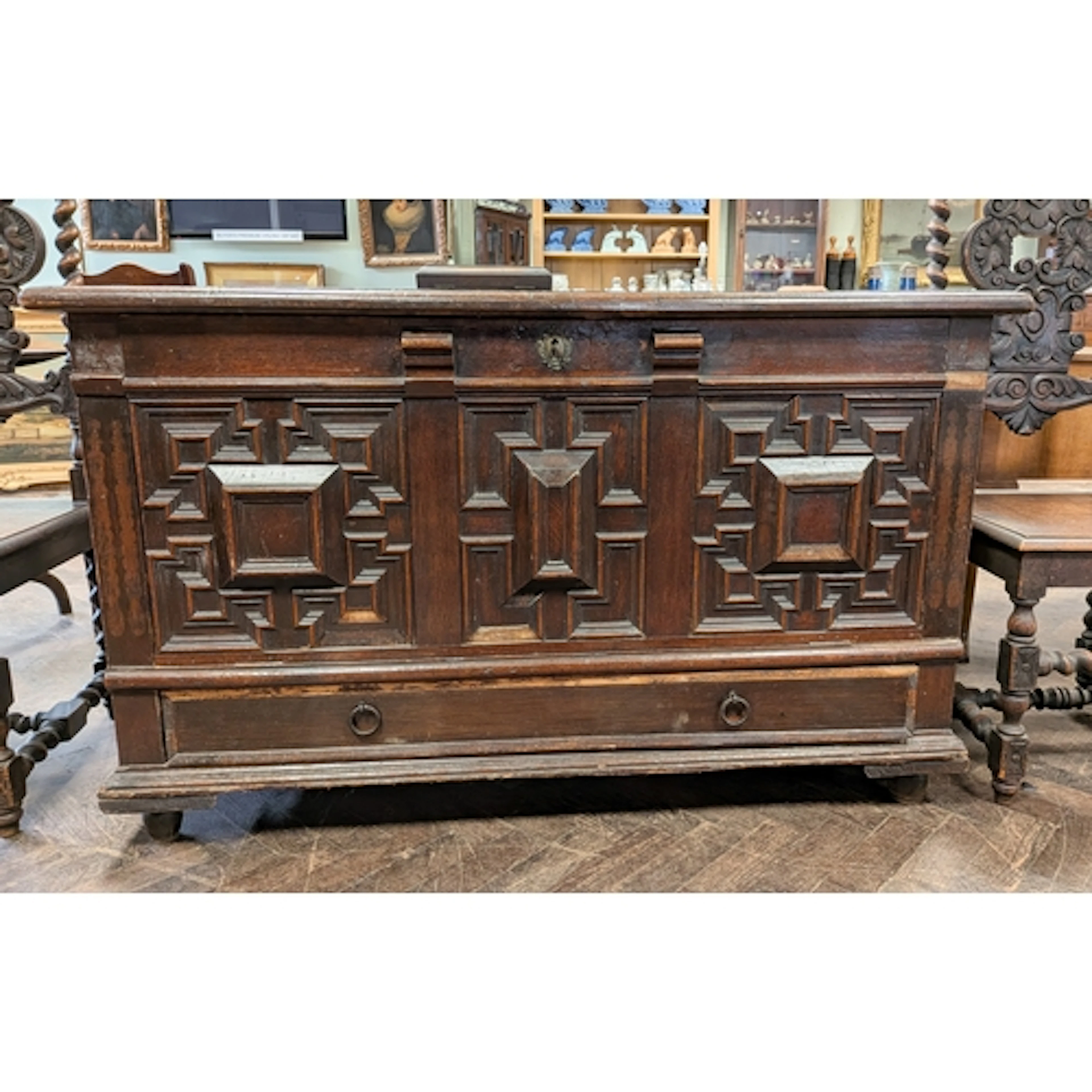 An antique oak coffer with three fielded panels and one long...