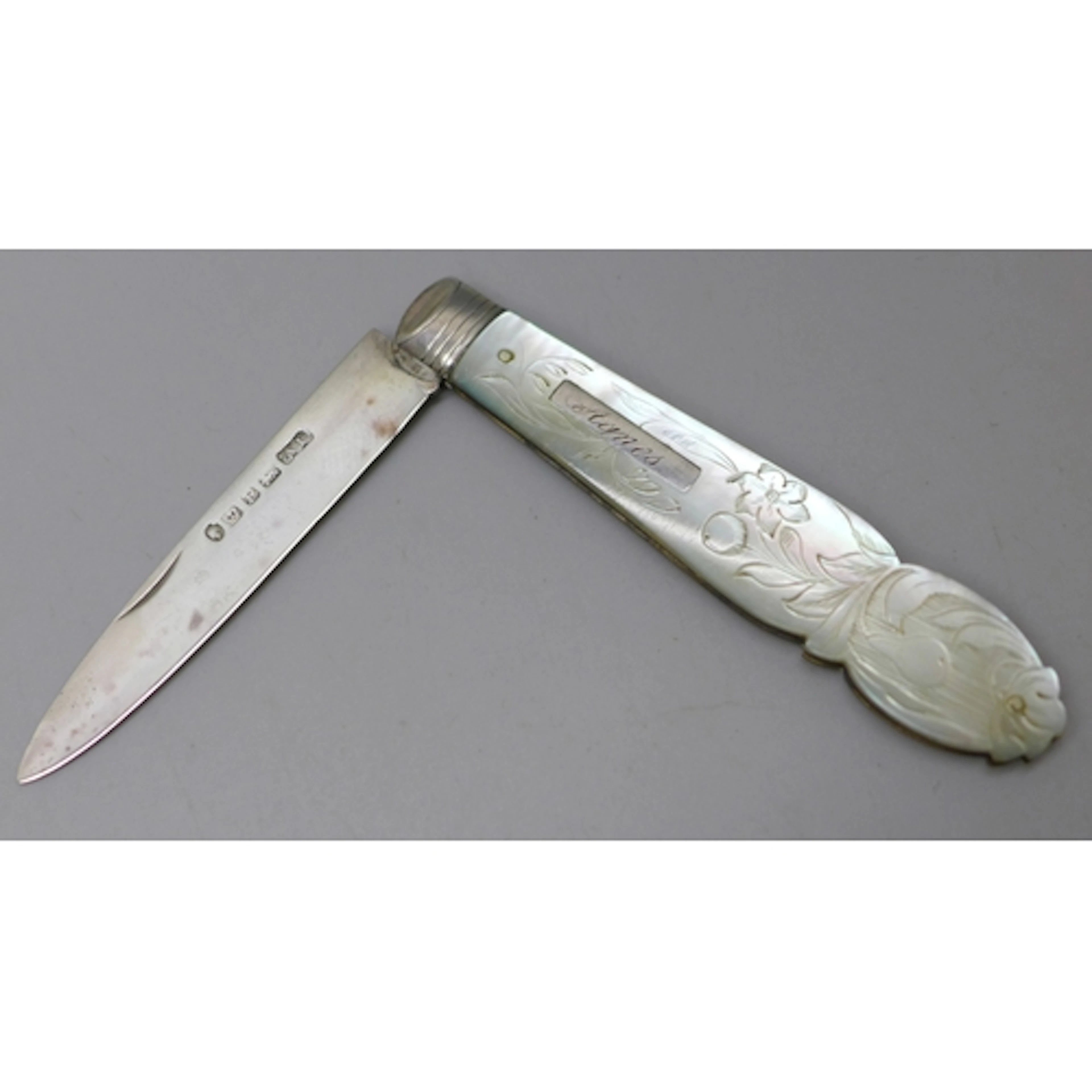 A Victorian carved mother of pearl fruit knife with a silver...