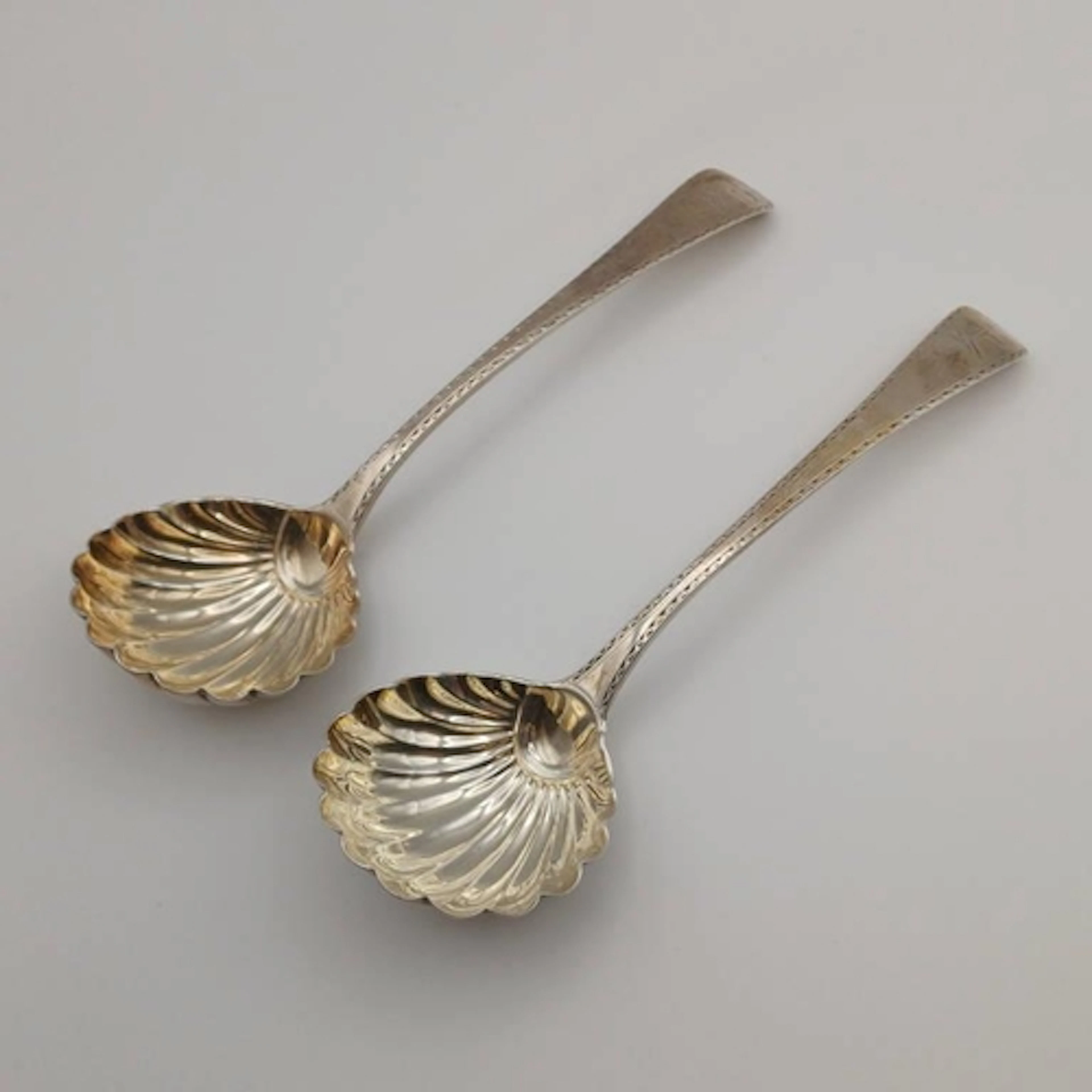 A PAIR OF GEORGE III SILVER BRIGHT CUT SAUCE LADLES WITH SCA...