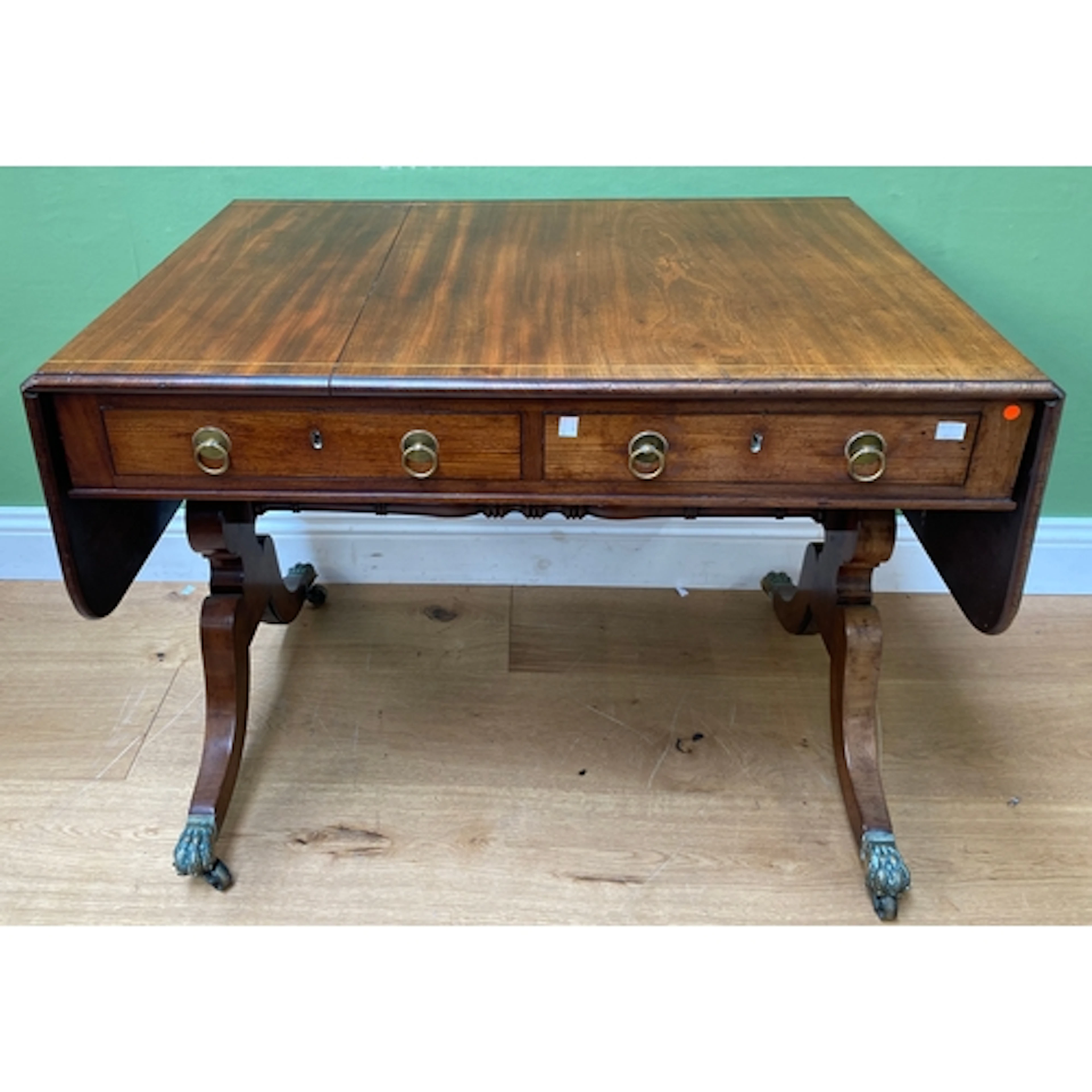 A Regency mahogany and line inlaid sofa table with two friez...
