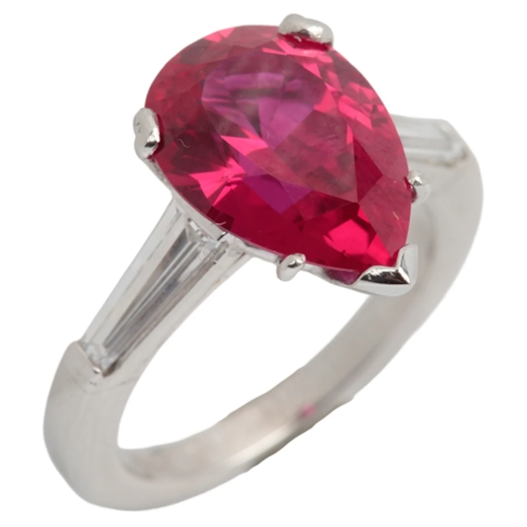A synthetic ruby and diamond ring, claw-set with a pear-shap...