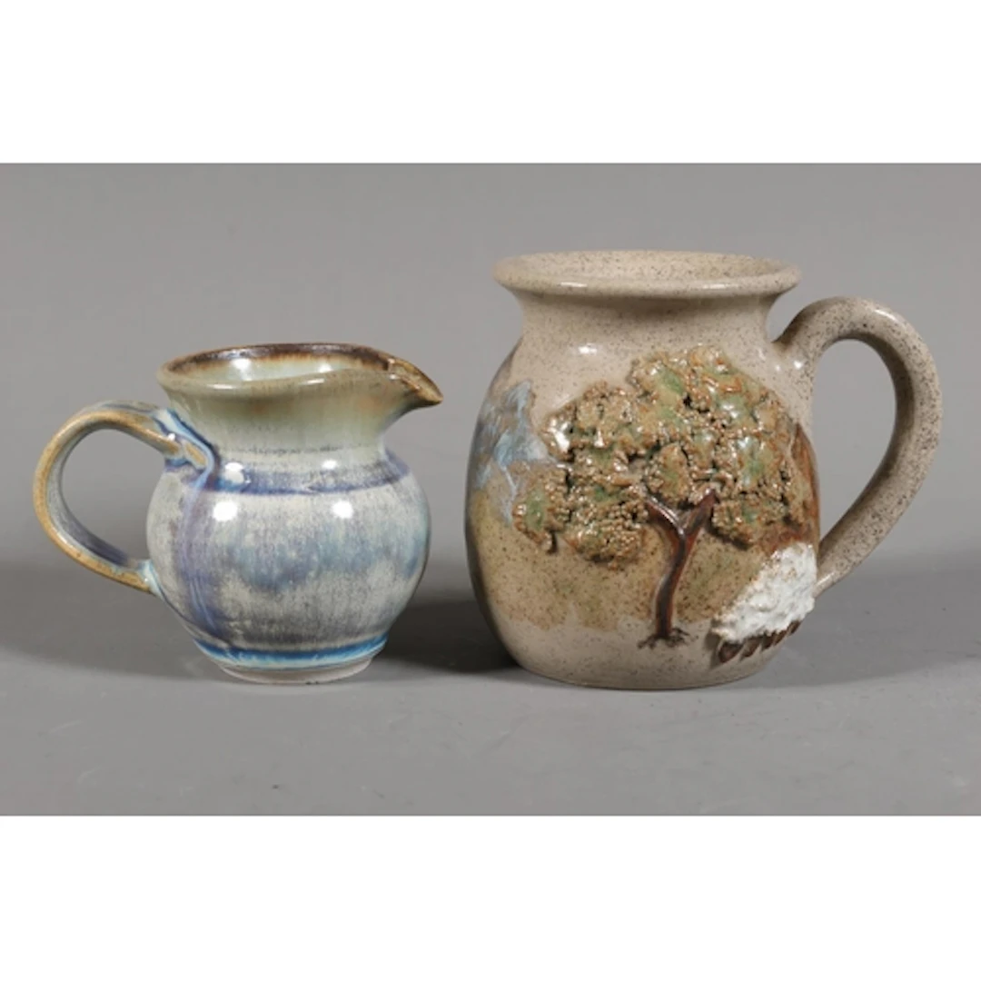 Arran Pottery mug and a St Andrews Pottery cream jug. ...