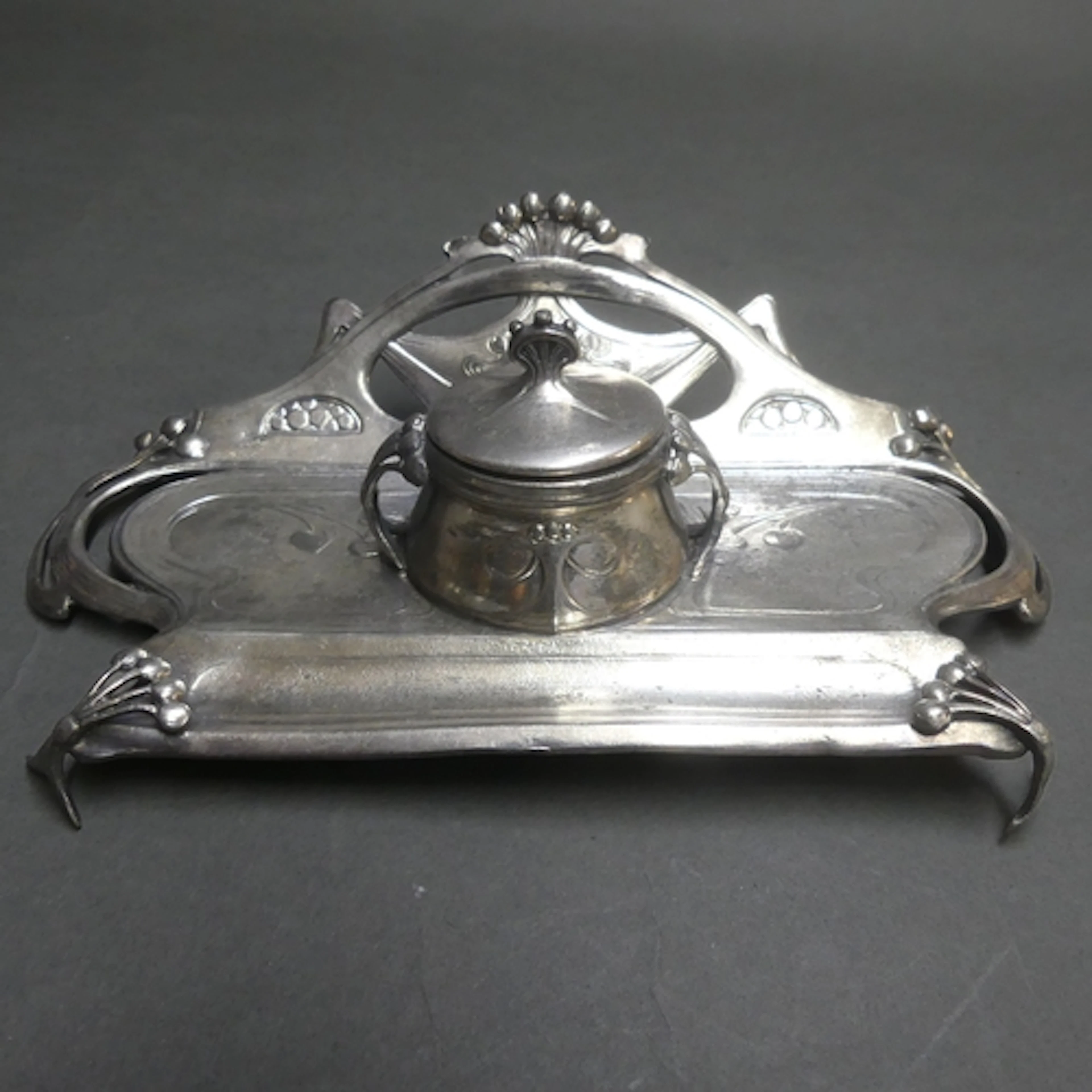 An Art Nouveau silver plated desk stand, central lidded inkw...