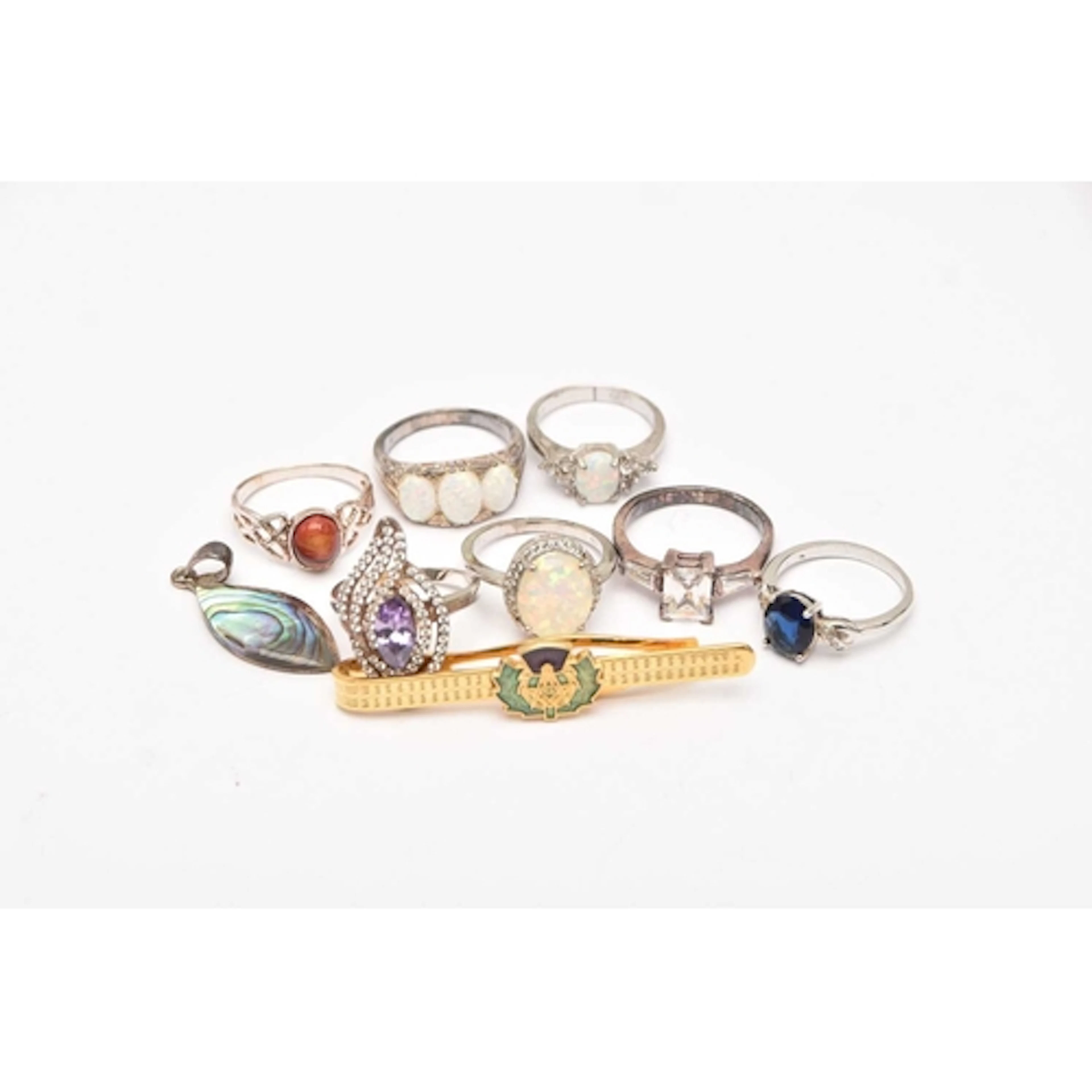 AN ASSORTMENT OF JEWELLERY, to include a tie slide, a white ...