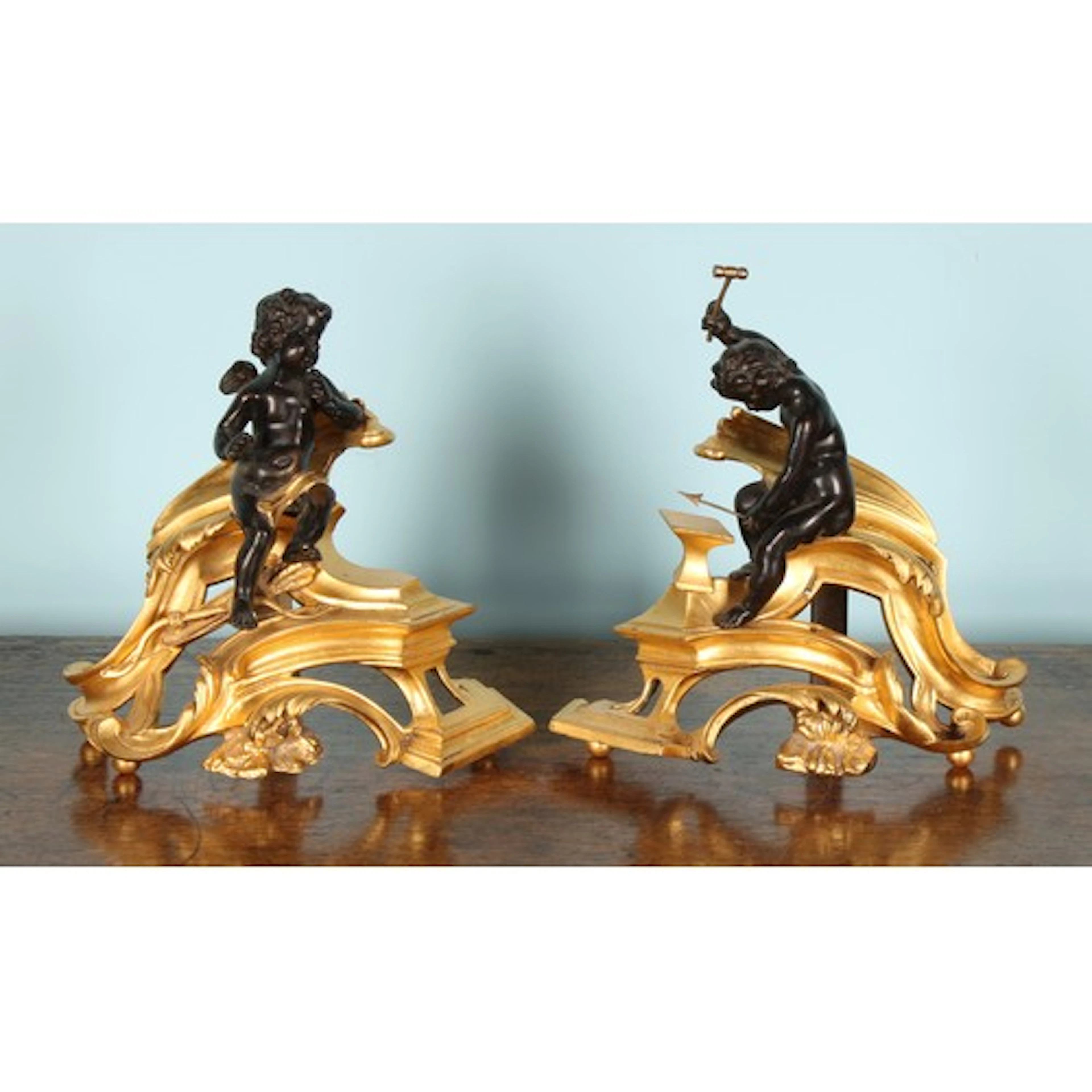 A pair of Rococo Revival bronze and gilt metal chenets, each...