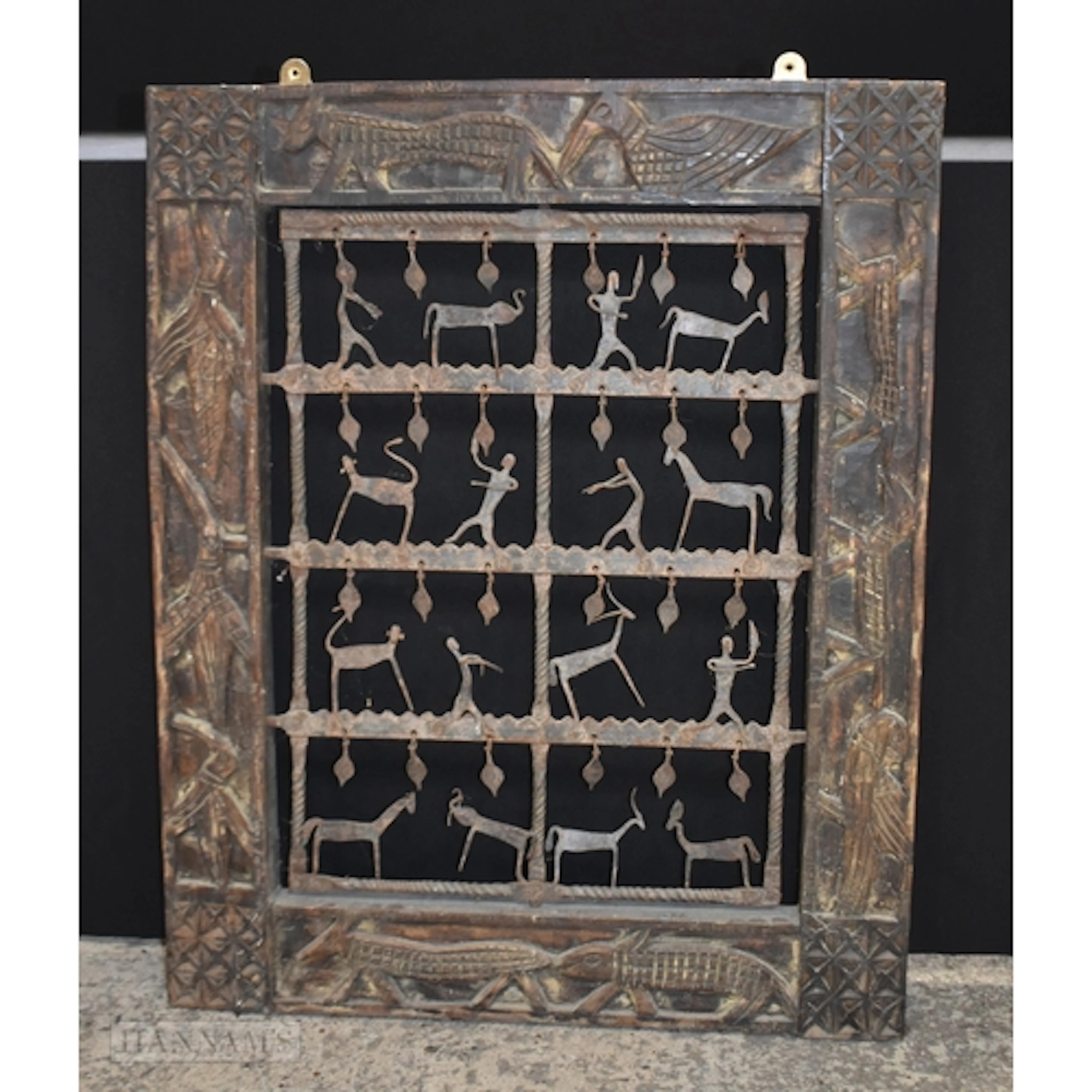 A carved wood African Tribal Dogon window framed decorated w...