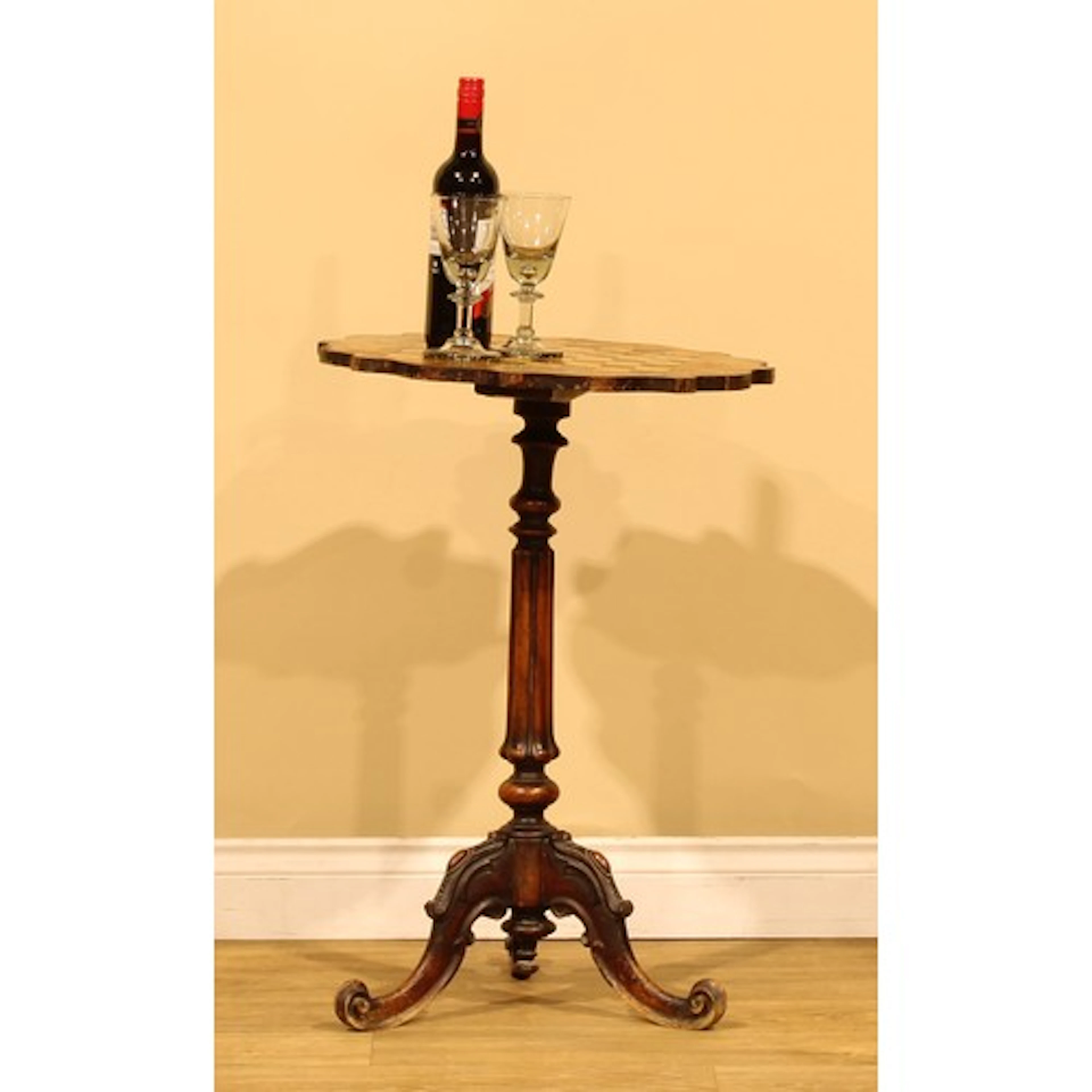 A Victorian walnut and parquetry tripod games table, shaped ...