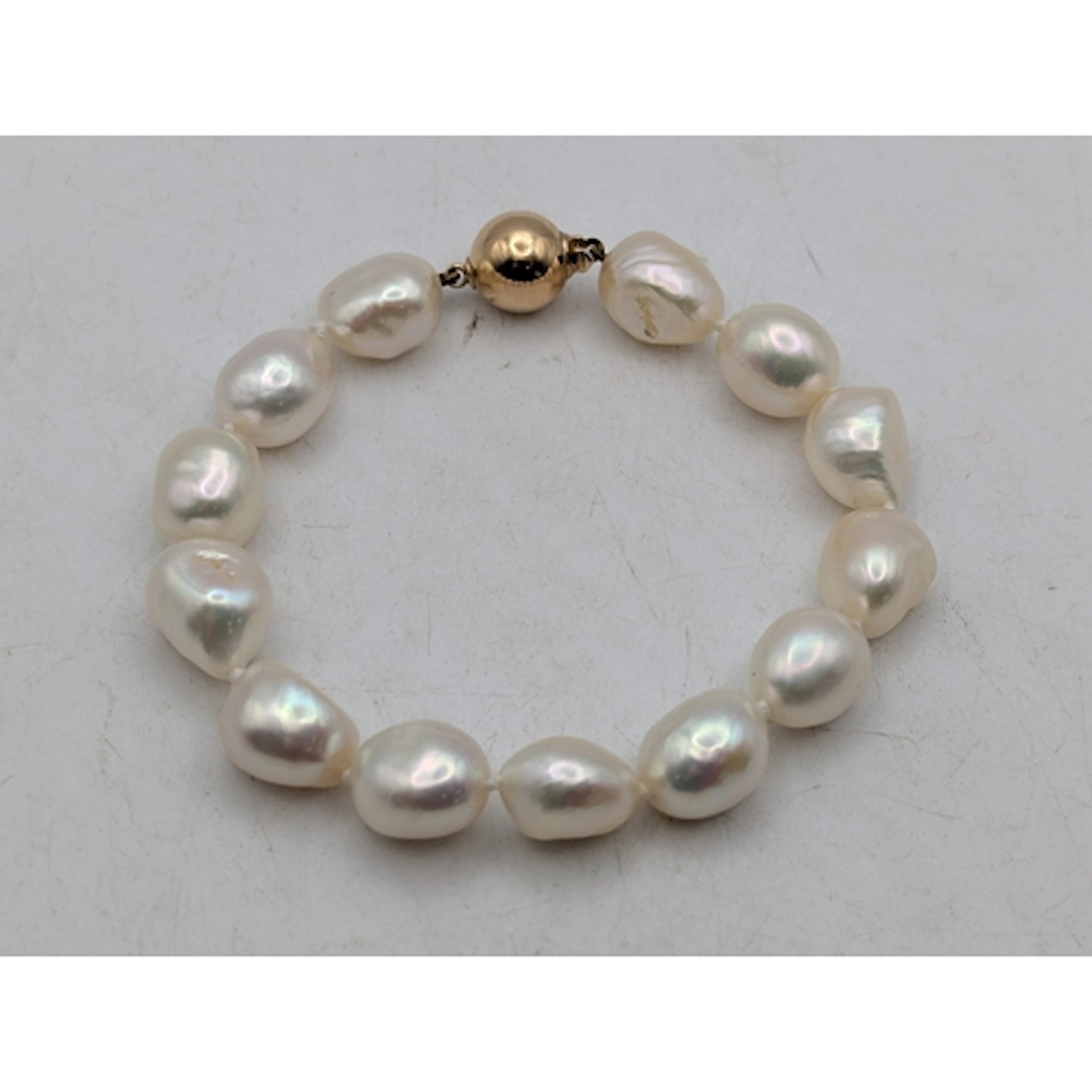A Baroque pearl bracelet having a 9ct gold ball and tongue c...