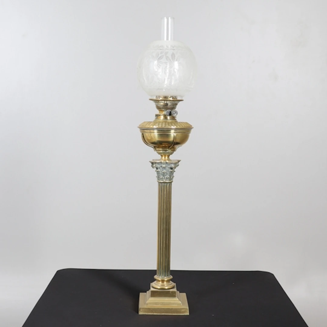 A VICTORIAN BRASS CORINTHIAN COLUMN OIL LAMP. the brass rese...