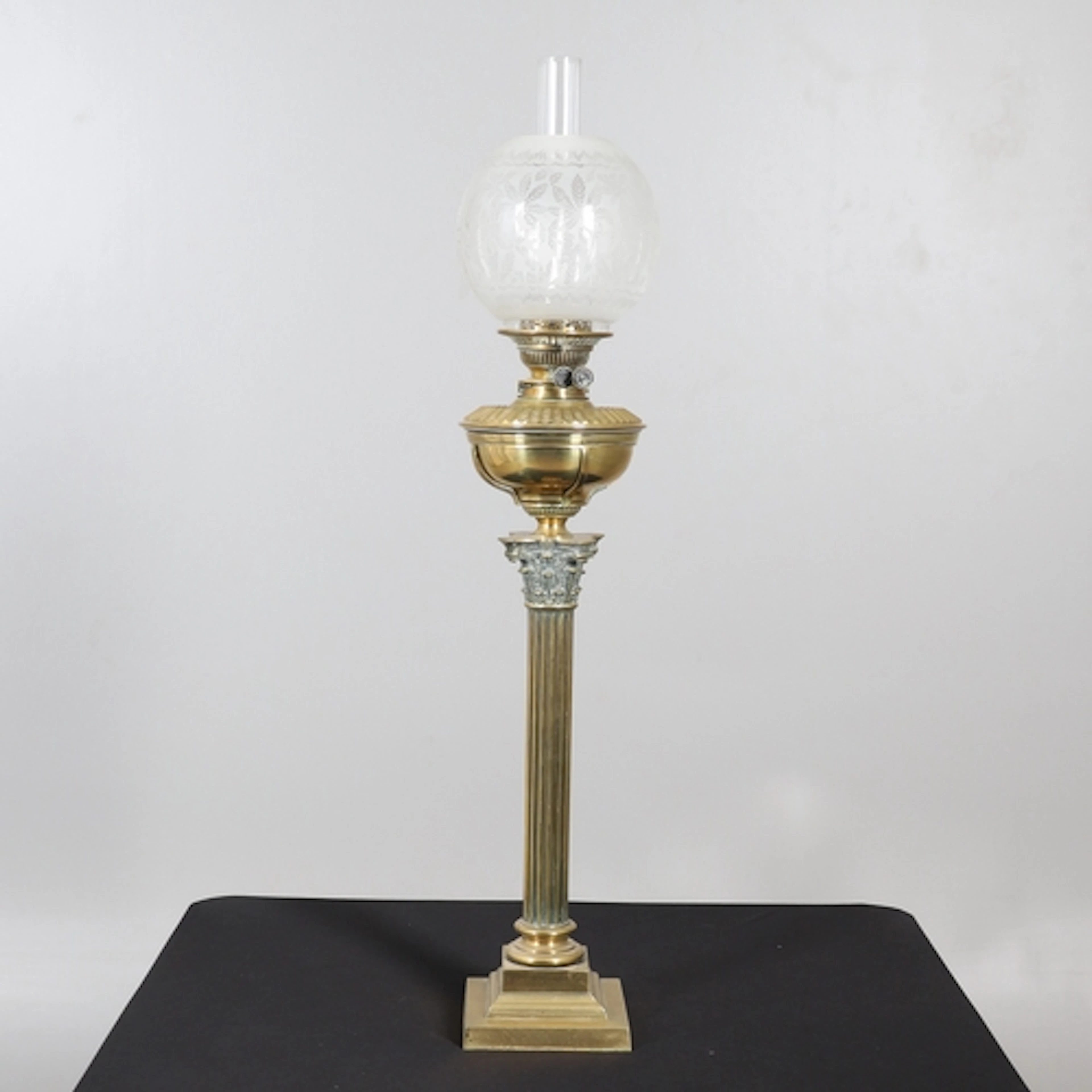 A VICTORIAN BRASS CORINTHIAN COLUMN OIL LAMP. the brass rese...