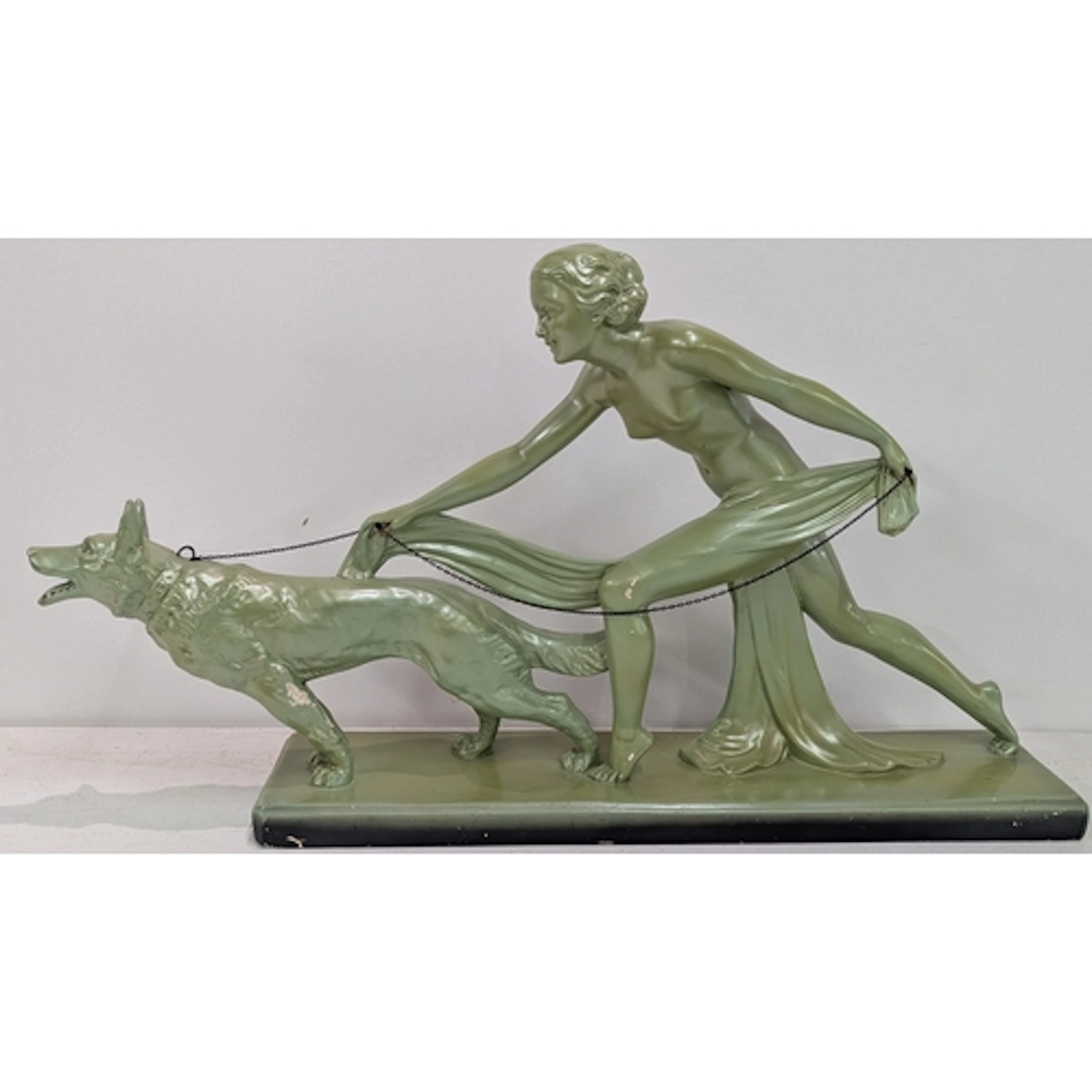 An Art Deco plaster figural group of a draped woman walking ...