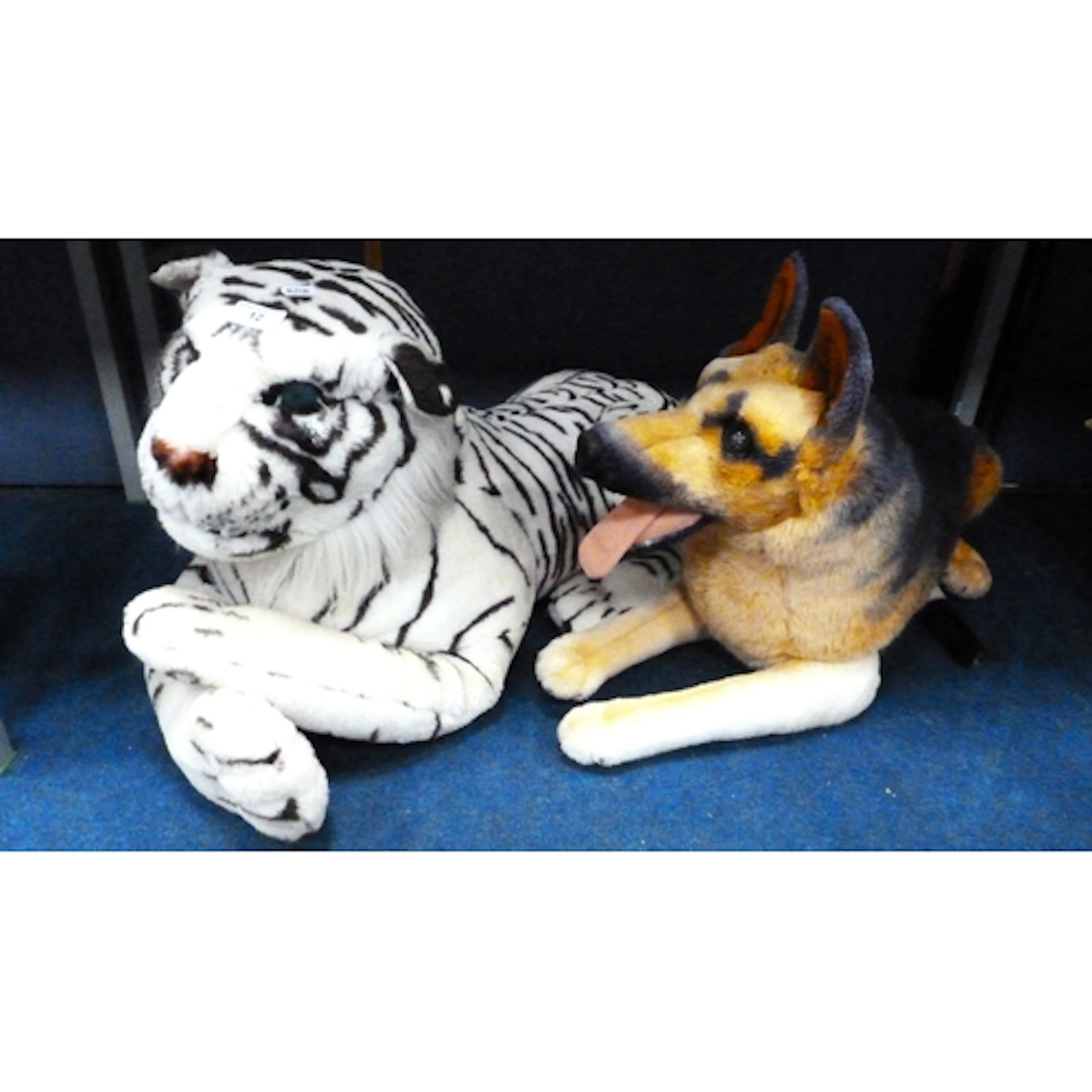 Two plush soft toys of a German Shepherd dog and a white tig...